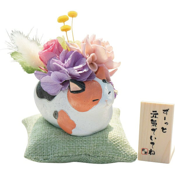 ●商品名/くつろぎ猫さん プリザーブドフラワー●商品内容/プリザーブドフラワーアレンジメント(約8×5.5×8cm・座布団付き高さ10cm)・座布団・木札・お手入れのしおり×各1●素材/プリザーブドフラワー(バラ、アジサイ、グリーンモス)、アートフラワー、ドライフラワー、和紐、器(猫・レジン製)●箱サイズ/約15×15×25cm●重量/約500g●原産国または加工地/日本製、花器・座布団:中国プリザーブドフラワーとは、生花を特殊加工して、鮮やかな花姿を長時間楽しめるようにしたお花です。水を与える必要がなく、色鮮やかなまま飾ることができ、お部屋を明るく演出してくれます。※写真と色・姿・サイズが異なる場合があります。直射日光の当たらない涼しい場所に置いてください。※メーカー都合により、デザイン・内容等が変更になる場合がございます。