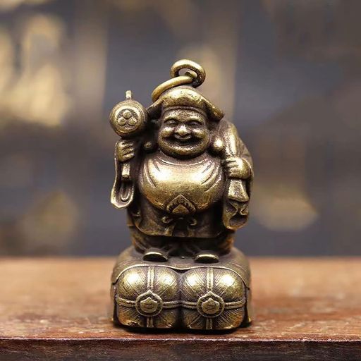 【材質と工芸】:私たちが使用している黄銅は品質と耐久性を保証するために厳選されています。黄銅は硬くて腐食に強いため、時間の試練に耐えることができます。 【サイズと重量】:サイズは家の財位に置くのにも、持ち歩くのにも適しており、財運のお守りとなります。50グラムの重さはこの小さな彫像をより重厚に見せ、重すぎて持ち運びの快適さを損なうことはありません。 【デザインの詳細】:金剛縄の結びは仏教の重要な象徴であり、不滅の力を代表しています。その追加により、視覚的にも意味的にも製品がより完全になります。微笑む顔から手に持つ宝物に至るまで、すべてのディテールは慈愛と豊かさを伝えるために細心の注意を払って設計されています。 【機能性】:底部の小さな口は巧妙に設計されており、願い事や小さなお守りなどを収納するプライベートなスペースを提供します。ノブはシンプルで使いやすく、軽く回すだけで簡単に開閉でき、実用性と美学を兼ね備えています。 【文化的な意味合い】:大黒天は日本文化において財産と繁栄の象徴であり、このような彫像を持つことは、より多くの幸運と財産を引き寄せることを意味しています。