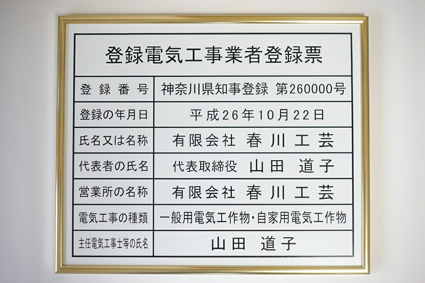 ■商品説明■ サイズ：W522mm×H407mm 板面：アルミ複合板（カラー：ホワイト） 額縁：アルミ製ゴールド額 文字：カッティングシート（カラー：ブラック） 書体：角ゴシック体（書体は変更可能） ■ご注文方法■ 1.ご注文後、当店よりご注文確認メールをお送りいたします。 2.商品の写真をご参照いただき、商品への記載内容をご連絡ください。 【イ】登録番号 【ロ】登録の年月日 【ハ】氏名又は名称 【二】代表者の氏名 (代表取締役等を記載する場合はその旨をお知らせください） 【ホ】営業所の名称 【ヘ】電気工事の種類 【ト】主任電気工事士等の氏名 ※書体の変更や レイアウトの確認をご希望の場合はその旨をご連絡ください。 3.記載内容を確定後、商品を作成させていただきます。土日祝を除き4日前後で発送させていただきます。 ※書体の変更や レイアウトの確認をご希望されている場合は、上記に加えて2日前後いただいております。ご了承ください。 ★法令サイズはこちら★・大判サイズ（W522mm×H407mm）の登録電気工事業者登録票です ・板面は丈夫なアルミ複合板（カラー：ホワイト）で作成しています ・ゴールドの額縁が登録電気工事業者登録票を引き立てる仕上がりです ・文字は印刷ではなくカッティング仕上げのため、文字変更の際は貼り替え可能 ・額の裏面に紐が付いているため、壁面への取り付けも簡単！