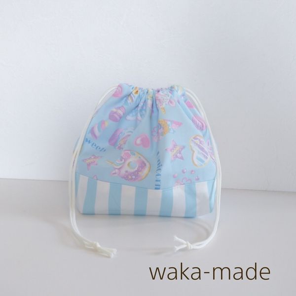 waka-madeの定番人気アイテム★ とってもかわいい巾着ランチバッグです(*'с'*)ノ お弁当やお子様のマグ＆離乳食入れなど、使い方はたくさん!! 1枚仕立てでお洗濯しても乾きやすく、かさばらないのでコンパクトにおさまります。 内側はジグザグミシンで丁寧に処理しました:) お子さまの小さな手でもしぼりやすい巾着になっています。 おそろい柄の給食袋もございます 洗い替えにたくさんコレクションしてくださいませ&#11804;( &#8226;&#8964;&#8226; )&#11805; サイズ：縦17cm×横28cm　マチ12cm 素材：コットンツイル 100％ ☆タグはランダムです ☆総柄生地を使用しているので、柄の出方に差がありますwaka-madeの定番人気アイテム★ランチバッグ