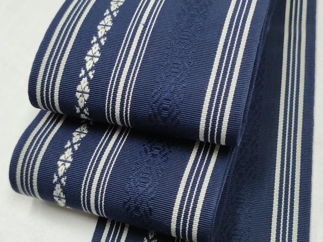 ■■■　サイズ　■■■ 長さ 392cm 幅 8.5cm程 ■■■　商品詳細　■■■ 【正絹】 状態は接写画像のように裏地に薄い汚れがございますが その他表地は特に目立ったシミ汚れなどもなく大変良い状態です。 着用時には見えない部分になりますのであまり気にならずお召になれるかと思います。 本場筑前博多織は、福岡県福岡市博多区やその周辺で生産される絹織物です。 仏具のひとつである独鈷、華皿を基にした幾何学模様が織られています。 江戸時代に筑前藩主だった黒田長政が幕府への献上品にしたことから、博多献上、献上博多とも呼ばれます。 経糸が緯糸を包み込んで、表面には経糸だけ出て、横畝が際立って見える経畝織りという織りになっています。 30～60本の細い経糸を使うため、こしやはりがあり、地合が硬く、光沢感があります。 きちんと締まり、くずれにくい、締めやすい帯といわれています。 大変上質な逸品になります。 お安く出品致しますので、是非この機会にいかがでしょうか？ ※両側未かがりですが着用には問題ありません。 ■■■　注意事項　■■■ ■モニター発色の具合により色合いが異なる場合がございます。 ■寸法は多少の誤差が生じる場合がございますのでご了承ください。 ■縫込みの長さが左右非対称の場合は短い部分を記載しております。 左右非対称であってもご返品・お値引き等の保証は出来かねますので、ご了承の上ご購入をお願い致します。 ■シミ等のチェックには注意を払っておりますが、見落としがある場合もございますし、個人の見解も様々ですので神経質な方のご購入はお控えください。 ■汚れやシミの種類につきましては、専門ではない為、正確な判別が難しく商品説明では種類を特定せず、汚れやシミと記載させております。 恐れ入りますが、ご了承くださいますようお願い申し上げます。 ■箪笥に入っておりました着物や帯なので畳みシワや匂いがあるものもございます。 ■お休みは基本的に土日祝となりますが、その他臨時でお休みする場合がございますのでご了承ください。 ■商品の発送は平日のみの発送となります。 ■夜間と土曜、日曜日はお問い合わせの回答が遅れる場合がございます。 ■当店では、お直し、紋入れ、お手入れ等は承っておりません。 ■生地の状態（ヤケ、経年劣化等）によってはサイズ直しが出来ない場合がございます。 その点もどうかご了承のうえ、ご購入をお願いいたします。 ■弊社で取り扱う商品は一点ものにつき、時期や在庫状況に応じて金額が変更となる場合がございます。 ■検針は行っておりません。予めご了承いただきますようお願いいたします。 ■【洗える着物】と記載のある商品におきましては、商品お届け後に洗濯を行ってしまってからのご返品にはご対応しかねます。 念の為、専門店でのお手入れをお願いいたします。 ■写真に写っている物が全てになります。それ以外の付属品はございませんのでご了承ください。 ■状態に関する写真につきましては、掲載可能な写真枚数に限りがあるため、各箇所につき1枚参考画像を掲載しております。 ■着物のサイズ目安は下記を参考ください↓ ＜女性着物＞　お端折り次第で＋5cm　−1cmが着用可能サイズ 　例）身丈170cmの場合、身長160cm〜175cm ＜男性着物＞　身丈＋約25cm〜27cm程が適応身長 　例）身丈155cmの場合、身長180〜182cm