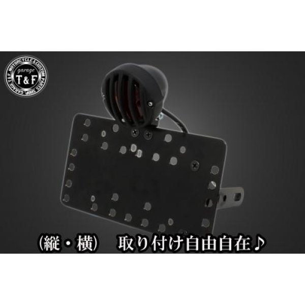 SN05925 ガレージT&F サイドナンバーキット&バードゲージテールランプ(スモールタイプ)ブラック/ブラック+ステー グラストラッカースズキ グラストラッカー(全年式)【本体の仕様】 ・素材:スチール製。 ・カラー:ブラック仕上げ。 【テールランプ取り付けステーの仕様】 ・素材: スチール製。 ・カラー:ブラック仕上げ。 【配線の役割】 ・赤色:ブレーキランプ(+)。 ・青色:ポジションランプ(+)。 ・黒色:アース(-)。 ※製造ロットによってテールランプの配線の色、長さが変更されることがございますので予めご了承ください。 【製品の特徴】 ・通常のサイドナンバーKITでは縦固定か横固定のみですが、本製品は縦横どちらにも対応。あなたのバイクスタイルに合わせた自由なレイアウトが可能です。 ・取り付けステーの角度調整や前後スライド調整が出来る為、ナンバープレートの位置を思い通りにセッティング可能。細部まで理想のスタイルを実現します。 ・横向きの場合:7か所の取り付け位置を選択可能。 ・縦向きの場合:12か所の取り付け位置を選択可能。 ・車種専用のステー付きです。加工不要で取り付け可能。 ガレージT&F製フラットフェンダーKITと同時装着される場合はサイドナンバーオフセットKITを同時にお買い求め下さい。 【注意事項】 ・ガレージT&F製サイドナンバーKITは取り付け位置にかなり自由度がございます。しかしながらテールランプの種類によっては取り付け位置が制限される場合がございます。 ・ガレージT&F製フラットフェンダーKITと同時装着する場合も取り付け位置が制限される場合がございます。 ・車種によっては、別売のサイドナンバーオフセットKITが必要となる場合がありますのでご注意ください。 ・装着イメージは画像は全てドラッグスター400となります。取り付される車種によって多少イメージが異なる場合がございます。予めご了承下さい。 商品の改良や生産工程の変更により掲載されている仕様やデザインが予告なく変更される場合がございます。 SN05925楽天 HD店
