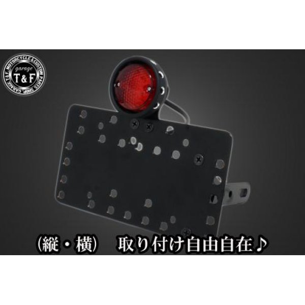SN00111 ガレージT&F サイドナンバーキット&ドリルドアイテールランプ(ブラック)+ステー マグナ50ホンダ マグナ50(全年式)【本体の仕様】 ・素材:スチール製。 ・カラー:ブラック仕上げ。 【テールランプ取り付けステーの仕様】 ・素材: スチール製。 ・カラー:ブラック仕上げ。 【配線の役割】 ・赤色:ブレーキランプ(+)。 ・青色:ポジションランプ(+)。 ・黒色:アース(-)。 ※製造ロットによってテールランプの配線の色、長さが変更されることがございますので予めご了承ください。 【製品の特徴】 ・通常のサイドナンバーKITでは縦固定か横固定のみですが、本製品は縦横どちらにも対応。あなたのバイクスタイルに合わせた自由なレイアウトが可能です。 ・取り付けステーの角度調整や前後スライド調整が出来る為、ナンバープレートの位置を思い通りにセッティング可能。細部まで理想のスタイルを実現します。 ・横向きの場合:7か所の取り付け位置を選択可能。 ・縦向きの場合:12か所の取り付け位置を選択可能。 ・車種専用のステー付きです。加工不要で取り付け可能。 ガレージT&F製フラットフェンダーKITと同時装着される場合はサイドナンバーオフセットKITを同時にお買い求め下さい。 【注意事項】 ・ガレージT&F製サイドナンバーKITは取り付け位置にかなり自由度がございます。しかしながらテールランプの種類によっては取り付け位置が制限される場合がございます。 ・ガレージT&F製フラットフェンダーKITと同時装着する場合も取り付け位置が制限される場合がございます。 ・車種によっては、別売のサイドナンバーオフセットKITが必要となる場合がありますのでご注意ください。 ・装着イメージは画像は全てドラッグスター400となります。取り付される車種によって多少イメージが異なる場合がございます。予めご了承下さい。 商品の改良や生産工程の変更により掲載されている仕様やデザインが予告なく変更される場合がございます。 SN00111楽天 JP店