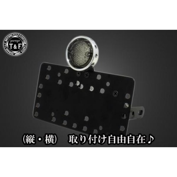 SN00417 ガレージT&F サイドナンバーキット&ドリルドアイテールランプ(ポリッシュ)スモークレンズ+ステー バルカン400/クラシックカワサキ バルカン400 / 400クラシック(全年式) 型式VN400【本体の仕様】 ・素材:スチール製。 ・カラー:ブラック仕上げ。 【テールランプ取り付けステーの仕様】 ・素材: スチール製。 ・カラー:ブラック仕上げ。 【配線の役割】 ・赤色:ブレーキランプ(+)。 ・青色:ポジションランプ(+)。 ・黒色:アース(-)。 ※製造ロットによってテールランプの配線の色、長さが変更されることがございますので予めご了承ください。 【製品の特徴】 ・通常のサイドナンバーKITでは縦固定か横固定のみですが、本製品は縦横どちらにも対応。あなたのバイクスタイルに合わせた自由なレイアウトが可能です。 ・取り付けステーの角度調整や前後スライド調整が出来る為、ナンバープレートの位置を思い通りにセッティング可能。細部まで理想のスタイルを実現します。 ・横向きの場合:7か所の取り付け位置を選択可能。 ・縦向きの場合:12か所の取り付け位置を選択可能。 ・車種専用のステー付きです。加工不要で取り付け可能。 ガレージT&F製フラットフェンダーKITと同時装着される場合はサイドナンバーオフセットKITを同時にお買い求め下さい。 【注意事項】 ・ガレージT&F製サイドナンバーKITは取り付け位置にかなり自由度がございます。しかしながらテールランプの種類によっては取り付け位置が制限される場合がございます。 ・ガレージT&F製フラットフェンダーKITと同時装着する場合も取り付け位置が制限される場合がございます。 ・車種によっては、別売のサイドナンバーオフセットKITが必要となる場合がありますのでご注意ください。 ・装着イメージは画像は全てドラッグスター400となります。取り付される車種によって多少イメージが異なる場合がございます。予めご了承下さい。 商品の改良や生産工程の変更により掲載されている仕様やデザインが予告なく変更される場合がございます。 SN00417楽天 JP店