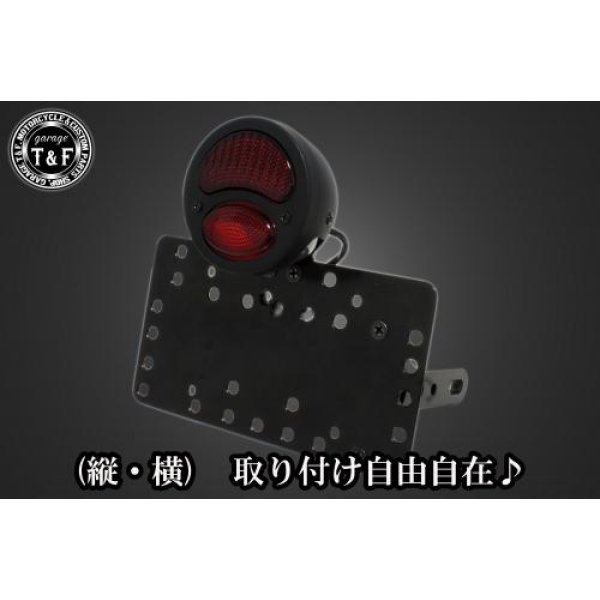 SN01719 ガレージT&F サイドナンバーキット&DUOテールランプ(デュアル)ブラック+ステー エストレアカワサキ エストレア / RS / カスタム / RSカスタム(全年式)【本体の仕様】 ・素材:スチール製。 ・カラー:ブラック仕上げ。 【テールランプ取り付けステーの仕様】 ・素材: スチール製。 ・カラー:ブラック仕上げ。 【配線の役割】 ・赤色:ブレーキランプ(+)。 ・青色:ポジションランプ(+)。 ・黒色:アース(-)。 ※製造ロットによってテールランプの配線の色、長さが変更されることがございますので予めご了承ください。 【製品の特徴】 ・通常のサイドナンバーKITでは縦固定か横固定のみですが、本製品は縦横どちらにも対応。あなたのバイクスタイルに合わせた自由なレイアウトが可能です。 ・取り付けステーの角度調整や前後スライド調整が出来る為、ナンバープレートの位置を思い通りにセッティング可能。細部まで理想のスタイルを実現します。 ・横向きの場合:7か所の取り付け位置を選択可能。 ・縦向きの場合:12か所の取り付け位置を選択可能。 ・車種専用のステー付きです。加工不要で取り付け可能。 ガレージT&F製フラットフェンダーKITと同時装着される場合はサイドナンバーオフセットKITを同時にお買い求め下さい。 【注意事項】 ・ガレージT&F製サイドナンバーKITは取り付け位置にかなり自由度がございます。しかしながらテールランプの種類によっては取り付け位置が制限される場合がございます。 ・ガレージT&F製フラットフェンダーKITと同時装着する場合も取り付け位置が制限される場合がございます。 ・車種によっては、別売のサイドナンバーオフセットKITが必要となる場合がありますのでご注意ください。 ・装着イメージは画像は全てドラッグスター400となります。取り付される車種によって多少イメージが異なる場合がございます。予めご了承下さい。 商品の改良や生産工程の変更により掲載されている仕様やデザインが予告なく変更される場合がございます。 SN01719楽天 JP店