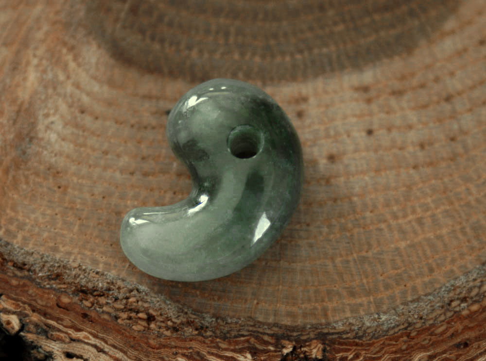 産地　：　糸魚川産（新潟県・国産） 制作　：　古吹 作 　　　　　地元糸魚川の職人 サイズ：　18mm*12mm*7mm 穴径　：　1.8mm 　この翡翠は地元糸魚川の天津神社(安産、合格、家内・交通安全)・奴奈川神社(縁結び)にてお清め（翡翠お清め神事）致しました。お守り・パワーストーンとしてお持ちいただければ幸いです。 当店の勾玉について 　当店の勾玉は糸魚川翡翠を素材に制作しています。 制作者も糸魚川ヒスイをこよなく愛する糸魚川の職人の手で制作いたしました。海外での制作は一切していません。日本固有のお守りですので、日本の伝統と文化を大切にしたいと考えております。 翡翠の勾玉について 　翡翠の玉は縄文時代中期（約5千年前）から奴奈川郷（糸魚川）で5世紀頃まで連綿と作り続けられてきました。その玉の霊力は全国に知られ、求められ配られていきました。 特にこの地域の特殊な技術で磨かれた翡翠製の勾玉には不思議な力を持っていると考えられていました。 勾玉は魂を意味し、悪い魂を鎮め、善い魂の力をそれを持つ人に与えてくれると考えられていました。 　皇室の三種の神器の1つの八坂瓊勾玉（やさかにのまがたま）は糸魚川産の翡翠製大珠とされています。右画像翡翠原石より制作 こちらの勾玉は右画像翡翠原石（青海産）より制作しました。（通称：古吹作半琅玕(ロウカン)勾玉） 商品のご紹介 　こちらの勾玉は糸魚川硬玉ヒスイ（国産）を素材に制作したものです。糸魚川の翡翠産地は天然記念物に指定され、現在では採掘は禁止されています。緑色、透明な翡翠は極端に少なくなってきているのが現状です。 　この勾玉は糸魚川在住（新潟県）の職人によって制作しました。糸魚川翡翠は5,000年以上前の古来よりお守りとして、また幸福を呼ぶ最高のパワーストーンとして尊ばれてきました。 糸魚川翡翠がまぼろしの翡翠と呼ばれる所以 　 　糸魚川翡翠は、縄文時代前期のころに出現し、その後、弥生・古墳時代を通じ、装身具・玉類の主流を占めていました。ところが、奈良時代のころになると翡翠は忽然として姿を消してしまいました。今なお、糸魚川の翡翠は、その出現から終末に至るまでの多くは謎につつまれています。糸魚川翡翠の希少さもさることながら、まぼろしの翡翠、謎の翡翠と呼ばれる所以がここにあります。 ご注意 　当店の画像につきまして、実物を忠実に再現することに全力をつくしておりますが、実際の色合いと多少異なる場合があります。当店の能力では、現状、多くて1日に4〜5点の作品しか撮影、出品することができません。 実物を忠実に再現することに多くの時間を費やしておりますが、どうしても異なる場合もございます。 画像と実物が著しく異なる場合、ご返品には応じますので、ご了承いただければ、幸いです。 ラッピングについて 　「糸魚川ヒスイの店」の「まがたま」は、当店オリジナルの桐箱に入れて配送致します。 神々が愛した宝玉　糸魚川翡翠 　神代の時代、糸魚川周辺と特産品である祭祀具「翡翠」を支配していた巫女王がいました。 巫女王の名は奴奈川姫（当店翡翠お清め神事を行っている奴奈川神社の祭神）。奴奈川姫はこの地で磨かれた翡翠に世の平安の願いを込め、日本全国に翡翠を伝播させたと伝えられています。 姫は賢く美しく、その噂を聞いて、出雲の国　大国主命（出雲大社の祭神）がはるばる当地方に訪れ、求婚を申し込んだと言います。姫は大国主命に歌を贈答し一日後に求婚を受け入れ、結婚したと伝えられています。二人の間には諏訪大社の神「建御名方命」が生まれました。 　神話が物語るように大国主命を奉る出雲大社本殿の裏の真名井遺跡からは、日本でも最高の品質と思われる翡翠の勾玉が出土し、大社に保管されています。