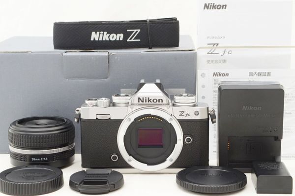 ＊集合写真1枚目の物がすべてです。 万が一商品説明の付属品と写真に相違がある場合は必ず質問ください。 ・注意事項：お使いのモニターの発色具合によって、実際のものと色が異なる場合がございます。 Nikon Z fc 28/2.8 SE Special Edition レンズキット Shot数 僅か 200枚前後！ メーカー名 Nikon Z シリーズ 外観チェック ボディ、レンズ共に 使用感ほぼ無く、極美品の外観です。 外装にスレキズは確認出来ず、 テカリの発生も見られません。 商品画像を沢山ご用意いたしましたので 細部までご確認ください。 光学チェック ━ボディ イメージセンサーは問題無くクリアです。 液晶モニターにもスレキズは無くとても綺麗です。 Shot数も僅か200枚前後と、 内部シャッター機構も未使用に近く 永くご使用いただけるグッドコンディションです。 ━レンズ レンズ内ホコリの混入も 僅かで、とてもクリアです。 勿論カビやクモリは全くございません。 動作チェック 当方のテスト撮影でも問題の無い安心商品です。 安心してお買い求めください。 万が一の初期不良には返品、返金対応させていただきます。 安心してご入札ください。 付属品 ━ボディ（Z fc） ・ボディキャップ（微かに薄いスレあり） ・バッテリー ・バッテリーチャージャー ・ストラップ ・未記入保証書（店舗印無し） ・使用説明書 ・元箱（バーコード無し） ━レンズ（NIKKOR Z 28mm F2.8 SE) ・フロントキャップ ・リアキャップ（薄いスレあり） ※未記入保証書はボディのみ付属。 シリアル B 2004265 L 30015311