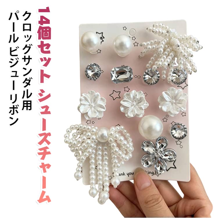 クロッグサンダルを自分好みにデコレーションできるシューズチャームです。パールやビジュー、リボン、お花などを贅沢にあしらった14個セット。靴に付けるだけで簡単にオリジナルデザインが楽しめ、キラキラとした仕上がりが可愛いと評判です。レディースからキッズ、ガールズまで幅広くお使いいただけます。プレゼントやDIYのアクセントとしてもおすすめです。 サイズ 14個セット サイズについての説明 サイズ：F※画像の商品は光の照射や角度により、実物と色味が異なる場合がございます。また表示のサイズ感と実物は若干異なる場合もございますので、予めご了承ください。※サイズ詳細等の測り方はスタッフ間で統一、徹底はしておりますが、実寸は商品によって若干の誤差がある場合がございますので、予めご了承ください。 素材 プラスチック 色 写真色 備考 ●サイズ詳細等の測り方はスタッフ間で統一、徹底はしておりますが、実寸は商品によって若干の誤差(1cm～3cm )がある場合がございますので、予めご了承ください。 ●製造ロットにより、細部形状の違いや、同色でも色味に多少の誤差が生じます。 ●パッケージは改良のため予告なく仕様を変更する場合があります。 ▼商品の色は、撮影時の光や、お客様のモニターの色具合などにより、実際の商品と異なる場合がございます。あらかじめ、ご了承ください。 ▼生地の特性上、やや匂いが強く感じられるものもございます。数日のご使用や陰干しなどで気になる匂いはほとんど感じられなくなります。 ▼同じ商品でも生産時期により形やサイズ、カラーに多少の誤差が生じる場合もございます。 ▼他店舗でも在庫を共有して販売をしている為、受注後欠品となる場合もございます。予め、ご了承お願い申し上げます。 ▼出荷前に全て検品を行っておりますが、万が一商品に不具合があった場合は、お問い合わせフォームまたはメールよりご連絡頂けます様お願い申し上げます。速やかに対応致しますのでご安心ください。