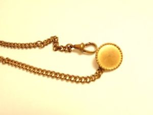 ̵ӻסܥۡ륢󥫡older brass colored watch chain with a butt...