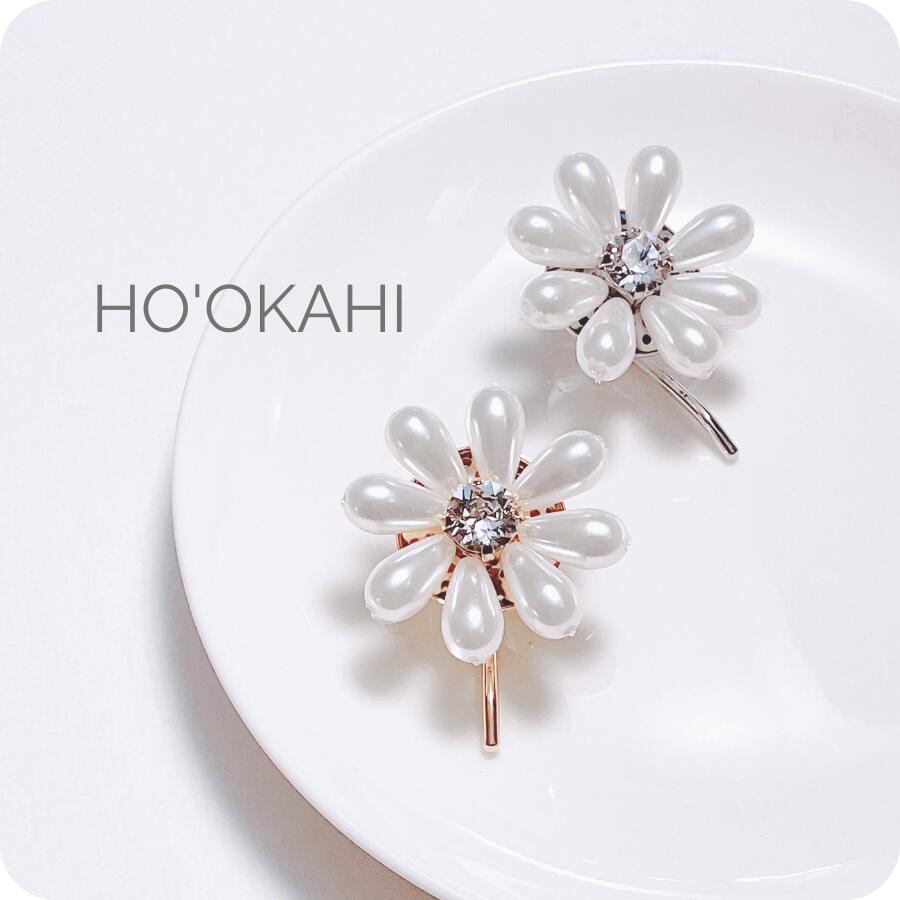 お花をモチーフにしたヘアアレンジアイテムです。 肌なじみの良いパールの真ん中には、キラキラと光り輝く大粒のクリスタルガラスを使用。 存在感溢れる程よいボリュームの大人のポニーフックです。 ポニーテールやシニヨンなどのまとめ髪をした際に装着す...