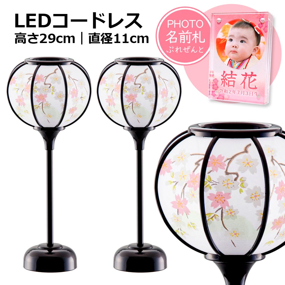 おひな様のお顔をより美しく見せる！LEDコードレス電池灯の雪洞（ぼんぼり）です。単品価格1万円以上の雛人形をご購入の場合は、ぼんぼりを10％OFFでご提供！昔ながらの伝統的な「雛ぼんぼり」です。優しいほのかな光りでおひな様にあかりを添えます。夜間は雪洞（ぼんぼり）にあかりを灯して趣きある雛飾りをお楽しみください。こちらの商品はLEDコードレス電池灯を使用していますので、場所を選ばずにお好きなところでご使用いただけます。当店ではさまざまな種類・カラー・サイズのぼんぼりをご用意しております。雛人形の大きさやお色目に合ったものをお選びください。★フォト名前札について初節句の記念に！顔写真が入れられるフォト名前札を無料プレゼント！「このサイズの名前札が欲しかったぁ〜」とご好評いただいております。マグネット式の高透明度アクリル板を2枚使用、表面は写真用、裏面にはお名前・生年月日・ひと言メッセージ・出生時記録を入れることが出来ます。【フォト名前札のご確認事項】※1商品につき1個のみ無料です。フォト名前札のみを追加でご希望の場合は別途単品（800円）でご注文ください。※表面ご使用の場合はご自身で顔写真を切り貼りしていただく必要がございます。※当店で顔写真を丸く切り抜き加工したうえで印刷する場合は別途＋300円の追加料金がかかります。←ご注文履歴のお問合せから画像を添付ください。フォト名前札（定価800円）の単品販売はこちら【サイズ】高さ29cm　直径11cm【内　容】一対（2個）入り【仕　様】LEDコードレス（単四電池付）【素　材】黒塗り・PC製【価格訂正について】 追加料金の発生および同時購入割引による価格修正につきましてはご注文完了後、当店にて金額を訂正いたします。【ご利用ガイド】お支払い方法・送料・ご返品・キャンセルにつきましてはご利用ガイドをご覧ください。【光る！雛人形 ぼんぼり】LEDコードレス 雅桜雪洞 黒塗り 29cm（直径11cm） ''雛人形 ぼんぼり 単品 コードレス led ひな人形 小さい コンパクト かわいい ちりめん お雛様 ミニ クリスタル 名前 札 桃久月