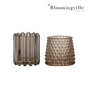 【BLOOMINGVILLE】ROSSLIN VOTIVE, BROWN, GLASS キャンドルホルダー ブラウン 2個セット ブルーミングビルのロスリンは、茶色のガラス製キャンドルホルダーの2個セット。 そのまま飾っても素敵ですが、キャンドルはもちろんLEDキャンドルを入れるだけでも雰囲気が抜群です。ティーライトキャンドルを灯せばガラスを通して雰囲気たっぷりのオレンジ色の明かりがお部屋を彩ります。花瓶と組み合わせて、ご自分の好きな居心地の良い空間をつくるのもおすすめ。 アクセサリー入れとして、お部屋のインテリアとしても活用出来ます。 ※ハンドメイド品のため色味やディテールは個々にユニークで多少異なります。 メーカー品質基準として表面の凹凸や気泡穴などの凹み、細かな擦れ傷や異物混入などにつきましては過度に状態が悪いものを除き良品扱いとなりますので予めご了承ください。 【BLOOMINGVILLE】 Bloomingvilleは、2000年にデンマークで設立されました。たった2名でスタートした会社は今ではヨーロッパ内40名を超える従業員と、40を超える代理店にまで成長しました。Bloomingvilleの空想的なデザインの製品は全て会社の専属デザイナーによって開発されています。フランスのブロカントに影響を受け、ノスタルジックなスカンジナビアデザインと最新のデザインを融合させたユニークなデザインに仕上がっています。