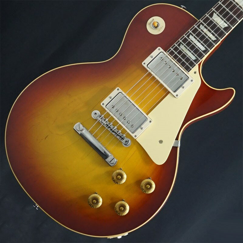 トム・マーフィーを主軸にカスタムショップ内に誕生したMurphy Lab！Ultra Light Agedの58 Les Paulの中古品が入荷！カスタムショップ内に誕生したMurphy Lab（マーフィー・ラボ）は、ナッシュヴィルのギブソン・カスタムショップ内に新設されたラボで、科学的検証に基づく最新の技術を駆使して、ギターのエイジング（ヴィンテージ・ギターの経時変化した外観と弾き心地を再現する処理）を専門に行います。ギブソン・カスタムショップの立ち上げ時のメンバーであり、ヒストリック・コレクション開発のプロジェクト・リーダーとして尽力したトム・マーフィーは、その後新品のギターにヴィンテージのルックスとフィーリングをもたらすエイジングというテクニックで活躍してきました。トムのヴィンテージ・ギターへの情熱と深い知識に裏打ちされた技術によって、ギブソン・ギターの自然なラッカーのクラック、演奏による摩耗を見事に再現しています。トム・マーフィーとギブソンは、経時変化によりウェザーチェックと呼ばれるクラックを生じさせる、1950年代、1960年代のニトロセルロースラッカーを科学的に解析し、その変化のプロセスをひも解き、あらゆるモデルのプロトタイプによるテストを重ねて、ヴィンテージ同様のナチュラル・ウェザーチェックを再現するラッカー・プロセスを開発しました。マーフィー・ラボは、トム・マーフィーがギブソン・カスタムショップのチームを率いて、プロトタイプをもとに、あらゆるボディシェイプ、フィニッシュ、エイジング・レベルの検証を始めたことから、その構想が生まれました。その結果、これまでにないリアリティとこだわりを追求したエイジングを行うために、ギブソン・カスタムショップ内に設立されました。トム・マーフィーの存在と、その芸術的な作品の数々は、ギブソンの歴史の中で重要な役割を果たし、今もそしてこれからもマーフィー・ラボとして永遠に引き継がれていきます。本機は4段階で設けられたエイジングレベルで最もダメージが軽微なコンディションの「Ultra Light Aged」が施された1958 Les Paul Standard Reissueです。エレキギター史に燦然と輝く「Burst」Les Paul Standard Model。数々のミュージシャンを虜にした圧倒的な存在感を放つサウンド、そして艶かしく弾き手を魅了する美しいボディラインは現代に於いても全てのロックギタリスト憧れのアイコンと言えるでしょう。1951年発売以来のゴールドトップ期を経て1958年にサンバーストフィニッシュを採用し、1960年までの僅かな期間にその姿で製作された「Les Paul Standard」。フラッグシップモデルとして君臨する1959リイシューに対して、1958リイシューはプレーンメイプルトップ、やや厚みのあるグリップのネックシェイプに、1959年の途中まで採用されていた細身のフレットを再現した仕様が特徴となっております。潔くも美しいプレーントップがお好きな方や、特にプレイヤーの皆様から人気を集めるモデルです！Ultra Light Agedは長年ケースに入れて大事に保管されていたかのような、最小限のダメージに抑えられた経年変化の風合いが自然に表現され、穏やかなウェザーチェックや打ち傷等の加工が施されております。指板エッジにはロールド加工が施され、優れたグリップ感がプレイヤーの皆様にはさらに嬉しい仕上げとなっております。基本的なスペックは最新のHistoric Specを採用。アンポッテッドのCustombucker Alnico IIIピックアップやアップデートされたアッセンブリ、True Historicパーツが引き続き装備されております。ピッキングに鋭く追従する鋭敏なレスポンスは、ギターをアンプにプラグインしたその刹那からプレイヤーを魔法の様にレスポールトーンの虜にしてしまいます！トーンを絞った際の音抜け感の良さは勿論のこと、ヴォリュームを絞っても程良くブライトさがキープされるコントローラブルなアッセンブリーは現代的な使用方法とも素晴らしい相性を見せてくれるでしょう！！当個体状態と致しましては、元よりエイジングが施されておりますが、ボディバックジャック付近に塗装チップが御座います。勿論電装系や演奏面も問題無く、フレットも凹み無く8割程度残っておりますのでガンガンお使い頂ける1本としてお迎え頂けます。サウンド、ルックスどれをとっても超一級品で、ヴィンテージに精通しているトム・マーフィーが参加したプロジェクト故のリアルな質感は、実際にヴィンテージを所有されている方でも納得のクオリティだと思います。トップラインでしか味わえないレスポールの最高峰。是非お見逃しの無い様！Weight≒3.98kgBody Wood : 2-Piece Maple Top & 1-Piece Lightweight MahoganyNeck : Solid Mahogany with Long Neck Tenon / 50s Rounded Medium CFingerboard : Indian RosewoodFrets : Historic Gibson Narrow/Tall 22FretsPickups: Custombucker Alnico III (Unpotted)Controls : 2 volume 、2 tone 、3-way switchBridge / Tailpiece : ABR-1 non wire/ Lightweight Tailpiece w/Long StudTuners : Kluson Single Line， Single RingHard ware color : Nickel， Murphy Lab Light Agedハードケース付属付属イケベカテゴリ_ギター_エレキギター_Gibson_Custom Shop_ユーズド JAN:2500010131322 登録日:2023/11/06 エレキギター ギブソン カスタムショップ