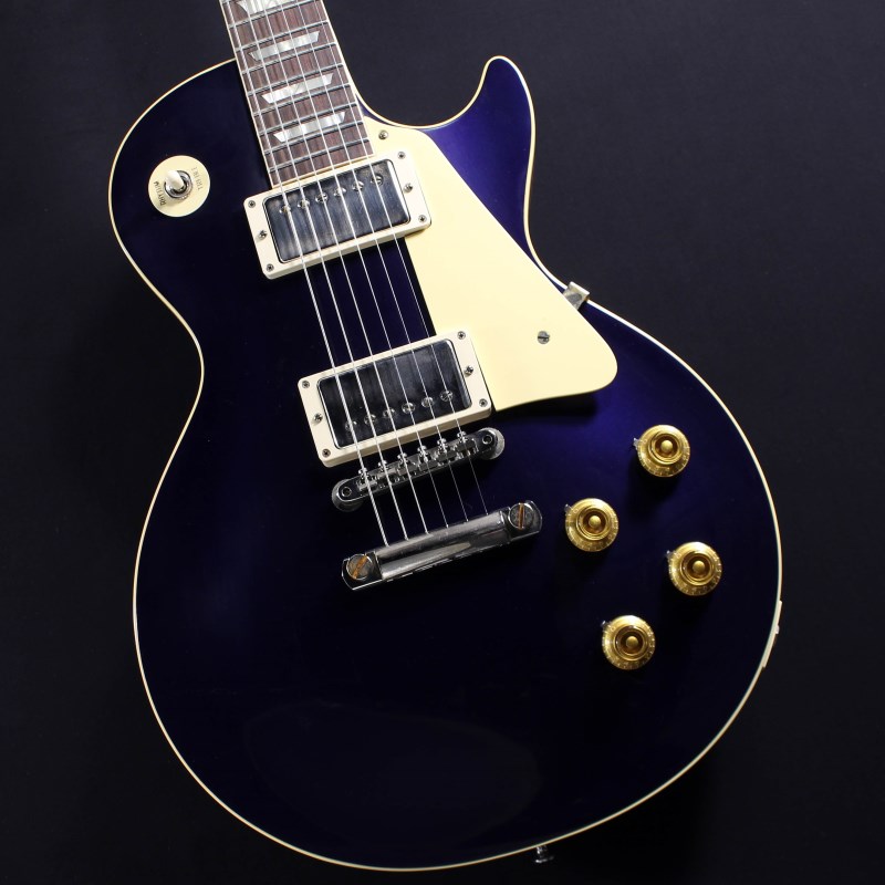 カスタムショップギブソンレスポール代表格、1957 Les Paul Standard　Japan Limited ！！深く蒼く、かすかに輝きを放つヴィンテージクラシックカーのようなメタリック塗装、Candey Apple Blueカラートップ！！ボディバックはナチュラルフィニッシュとなっており、VOS仕上げがより古き良き雰囲気を演出しております。勿論、ハードウェアやプラスチックのパーツ類にはTrue Historicパーツを採用し、金属パーツにもVOS仕上げと相性の良い軽度なエイジド加工が施されておりオールドテイストな魅力をより一層引き立てています。1957モデルではございますが、ネックは1959仕様となっており、2018年以降リファインされ、やや細身となったAuthentic 59 Medium C-Shapeネックとミディアムジャンボフレットを採用し、プレイアビリティは抜群です。ピックアップは近年の定番モデルとなっているCustombucker Alnico IIIを継続して採用しつつ、ポッティングをコイル部分、ベースプレートを含めた全面で廃し、キレがよくバイト感のある明瞭なサウンドキャラクターと本機の生鳴りが見事にブレンドされたサウンドが至福を与えてくれます。新たに搭載されたペーパーオイルコンデンサーやヴィンテージカーブを追及した500KのCTSポットを装備。通常仕様の500kΩポットに比べてボリュームを絞っても極端に高域が削られず、手元の操作でクリーンサウンドからドライブサウンドまでを自在に操ることができます。今まで以上にピッキングに鋭く追従する鋭敏なレスポンスは、ギターをアンプにプラグインしたその刹那からプレイヤーを魔法の様にレスポールトーンの虜にしてしまいます！トーンを絞った際の音抜け感の良さは勿論のこと、ヴォリュームを絞っても程良くブライトさがキープされるコントローラブルなアッセンブリーは現代的な使用方法とも素晴らしい相性を見せてくれるでしょう！！ルックス、サウンドとともに往年のレスポールファンの心を揺さぶる、定番でありながらも格別な逸品です！お見逃し無く！！#732307約3.97kgハードケース、認定書付属Body Top : 2-Piece Maple， Hide Glue FitBody Back : Light Solid MahoganyNeck : MahoganyNeck Profile : Authentic 59 Medium C-ShapeFingerboard : Indian Rosewood， Hide Glue FitTailpiece : Lightweight Aluminum Stop BarBridge : ABR-1 Non WireTuning Keys : Kluson ReisueRhythm Pickup : Custombucker Alnico III (Unpotted)Treble Pickup : Custombucker Alnico III (Unpotted)Controls : CTS 500K Audio Taper Potentiometers， Paper-in-Oil Capacitorsイケベカテゴリ_ギター_エレキギター_Gibson_Custom Shop_新品 JAN:4570156001337 登録日:2024/02/05 エレキギター ギブソン カスタムショップ