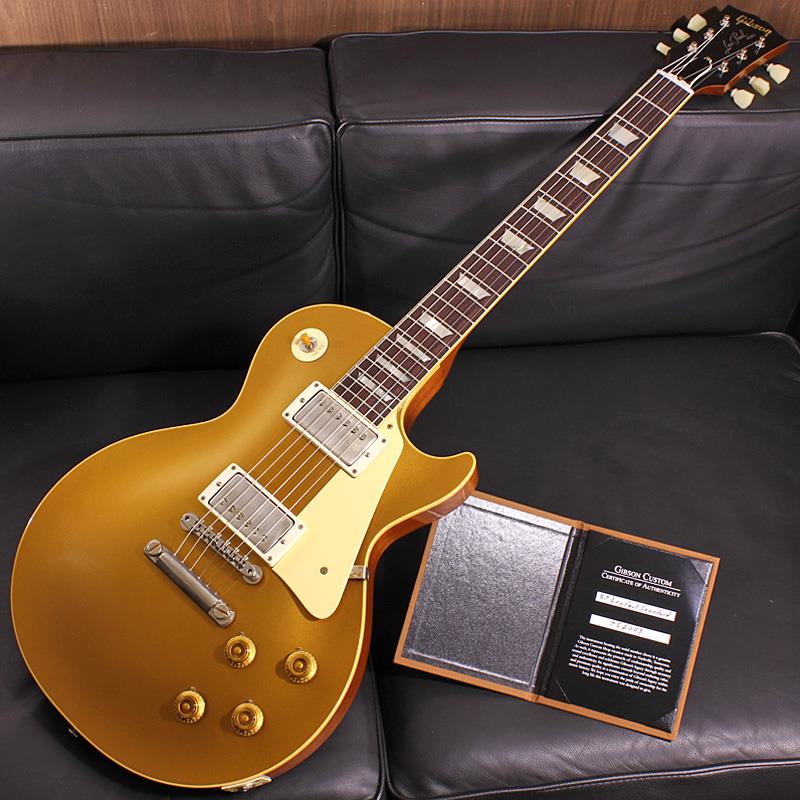 ■商品紹介Gibson Les Paulの最も愛される看板モデルのひとつ、1957 Les Paul Gold Topが入荷致しました！1952年に誕生したレスポールモデルはギブソン社の歩みとともに変更される、ルックス、サウンド、弾き味などの仕様遍歴がございますが、本機は50年代ゴールドトップの最終形態となるハムバッカーPU搭載の57Les Paul Goldtopです。ブリッジには後のバースト期まで採用されるチューン-0-マチック&ストップテイルピースが搭載されております。ボディトップはモデル名の通りDouble Goldと名付けられたゴールドカラーでフィニッシュ。見る角度、光の当たり具合によって、渋さのある深緑から、明るいグリーンゴールドの色合いまでの変化が楽しむことができます。レスポールならではの美しいボディのトップカーブが艶かしくカラーリングを更に引き立てており、バーストモデルとは一味違う存在感を放っております。勿論、ハードウェアやプラスチックのパーツ類にはTrue Historicパーツを採用し、金属パーツにはVOS仕上げと相性の良い軽度なエイジド加工が施されておりHistoricモデルらしいオールドテイストな魅力をより一層引き立てています。搭載されるピックアップは全面の含浸処理を廃したCustombucker Alnico IIIピックアップと、2019年から新しく採用されたバンブルビータイプのペーパーオイルコンデンサーやヴィンテージカーブを追及したCTSポットを併せて装備した2019ヒスコレスペック、オールドニュアンスを更に追求した抜群のレスポールサウンドが弾き手を楽しませてくれるでしょう。ネックグリップは厚すぎずもしっかりとしたCグリップ。適度な厚みを持ったネックから生まれる力強いヴァイブレーションと、エッジーなレスポンス感はこの57モデルならではです。フレットワイヤーには時代考証を顧みたJESCAR製のナロートールタイプを採用しており、ネックグリップの違いも含め、59Les Paul等と演奏時のフィーリングが異なる点が表現されているのも非常にユニークなポイントです。ルックス、サウンドとともにGold Topファンの心を揺さぶる、定番でありながらも格別な逸品です！お見逃し無く！！Serial No. 752003Weight≒4.08kg専用ブラウンケース、認定証 等付属■仕様詳細Body Wood: 2-Piece Plain Maple Top & 1-Piece Lightweight MahoganyNeck: Solid Mahogany with Long Neck Tenon / 50s Rounded Medium C-ShapeFingerboard: Indian RosewoodFrets: Historic Gibson Narrow/Tall 22FretsPickups: Custombucker Alnico III (Unpotted)Controls: 2 volume 、2 tone 、3-way switchBridge / Tailpiece: ABR-1 non wire/ Lightweight Tailpiece w/Long StudTuners: Kluson Single Line， Single Ring検索キーワード：イケベカテゴリ_エレキギター_レスポールタイプ_Gibson_Custom Shop_新品 SW_Gibson_新品 JAN:4580228786062 登録日:2026/03/28 エレキギター ギブソン カスタムショップ