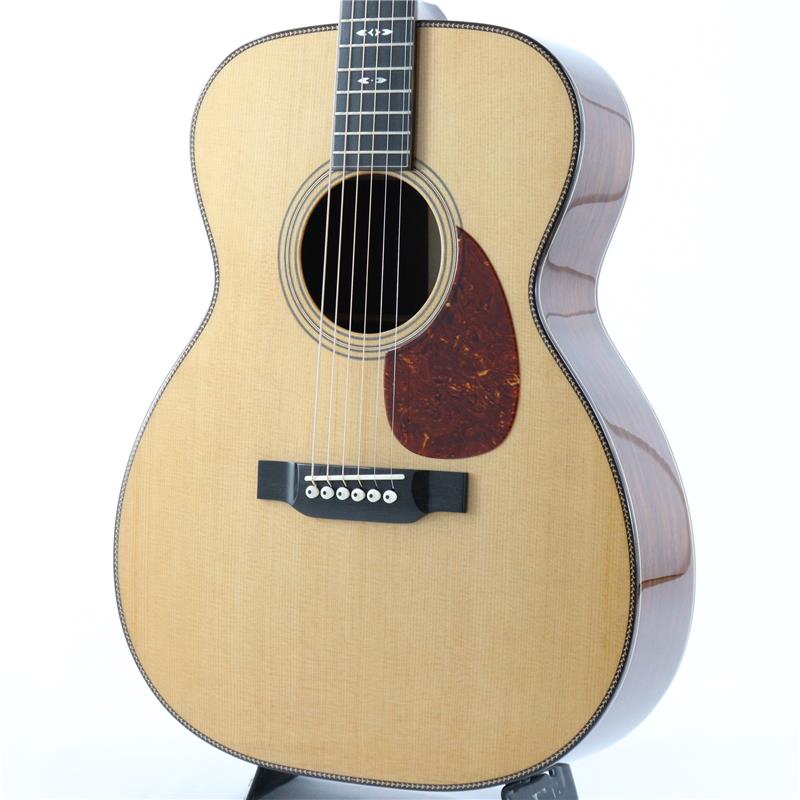 ■商品紹介イーストマン工場現地選定品！！ハートマンギターズの担当秋田が、11月に中国のEastman工場にて膨大なストックの中から選定してきた逸品です。トップ、バックの木目はもちろん細かいサウンドの違いまで、1本1本丁寧に選んでおります。ルックス・サウンド共に間違いなくおススメできる1本！！お見逃しなく！！--------------------------------- Bourgeois Guitars -ギター製作家「ダナ・ボジョア」が手掛けるBourgeois Guitars（ボジョアギターズ）は、コリングスやサンタクルーズと並び称されるアメリカのトップギターブランドです。厳選された材料と、確かな技術力、そしてダナ氏の豊富な経験から生まれる設計により製作されるギターは、「楽器としての精度の高さ」と「音楽的で豊かな音色」を併せ持ち、数多くのミュージシャンから高い評価を得ています。- Touchstone Series -Touchstone Series(タッチストーン・シリーズ)の魅力は、ダナ・ボジョアによるハンド・ヴォイシング・システム（材を叩いて音色を確認する、別名タップ・チューニング）にあります。過去50年にわたり、彼はこの古き良きテクニックを磨き上げ、現在では表板のヴォイシングの第一人者として世界的に認められております。世界最高級トーンウッドの繊維に秘められた潜在的な音色を読み取り、選りすぐりの表板が選別されています。それぞれの木材が持つ「音色」を最大限に引き出せるよう、表板の力木ひとつひとつを丹念に削り出し、ハンドヴォイシングをしながら音の確認を行います。タッチストーン・シリーズの表板が完成し、ダナによって最終チェックされた表板のみが真空密閉され、イーストマンの工房に出荷されます。そこでは、ボジョアの哲学と構造方法論を入念に学んだイーストマン選りすぐりのルシアーたちが、それぞれのギターに命を吹き込みます。本器は伝統的なボディスタイルに、ダナ・ボジョア氏のデザインセンスが光るSignatureと銘打たれたモデル。トリファイド加工が施されたシトカスプルーストップにアディロンダックスプルースブレーシング、マダガスカルローズウッドサイドバック、マホガニーネック、エボニー指板＆ブリッジ、シャーラーペグという大変贅沢なスペックとなっております。サウンドにおいても、オールUSAメイドのボジョアに劣りを見せない素晴らしい仕上がり。ボジョアらしい太く艶やかな基音とボリューム感のあるミッドレンジ、主張し過ぎることなく美しい余韻を演出する倍音と伸びやかなサスティーン。どれも絶妙なバランスで混ざり合っており、弾き手のニュアンスが引き立つ混じりけの無いピュアトーンを奏でます。サイドバックに希少材であるマダガスカルローズウッドを採用していることもあり、硬質で煌びやかでありながら独特の甘さを感じる上質な倍音が、ボジョアならではの前に音が飛んでいく基音に絶妙に絡み合う素晴らしい音色が大変魅力的なシリーズ。60万円台のというボジョアの中では大変お求めやすい価格帯のモデルとはなりますが、コストパフォーマンスという言葉で表してしまうのはもったいない程に、一切妥協のない造り込みで製作されており、圧倒的なサウンドクオリティを体感いただける楽器に仕上がっております。是非この機会にご体感くださいませ！！■仕様詳細Body Shap: OMTop Wood: Alaskan Sitka SpruceBack Sides:Madagascar RosewoodNeck: MahoganyFretboard: EbonyBridge: Ebony TraditionalScale Length: 25.5(647.7mm)Nut/Bridge Width: Nut-1 23/32(43.7mm) Bridge-2.2(55.8mm)Saddle: BoneTuners: Schaller Grand Tune NickelPins: IvoroidFinish: High GlossBracing: Adirondack Spruce検索キーワード：イケベカテゴリ_アコースティック・エレアコギター_アコースティックギター_Bourgeois_新品 SW_Bourgeois_新品 JAN:4582632727228 登録日:2025/12/15 アコースティックギター アコギ