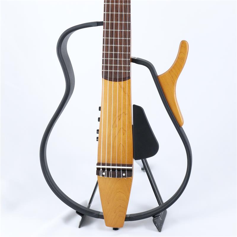 ■商品紹介現在は生産が終了しているヤマハのSLG-110Nの中古品！SLG110Nはナイロン弦のエレガットタイプギター。通常のクラシックギターよりもやや狭い指板幅と低めの弦高設定は、アコースティックギタープレーヤーや手の小さい方でも弾きやすいデザインです。優れた演奏性と美しいナイロン弦サウンドを備えた気軽に楽しめるモデルです。一般的なアコースティックギターに比べて、音のエネルギーでは100分の1、音量では10分の1という、優れた静粛性を誇ります。周囲に聞こえる音はごくわずかなので、夜間の練習はもちろん、リビングで家族といるときでも、リラックスしてギターをプレイすることができます。携帯音楽プレイヤーなどと接続できるAUX IN端子を装備。お気に入りの音楽をバックに演奏したり、好きなアーティストと一緒に演奏することができます。AUX IN用レベルコントロールで、バックの音量も手元で調整できます。状態的には、古いモデルということもあり、全体的に使用感はございます。一方、演奏面ではフレットの減りも見受けられず、ネックコンディションも良好ですのですぐにお使いいただけます。生産終了の貴重なサイレントギターの中古品をお探しの方におススメの個体です！■仕様詳細ボディ：ハードメイプルネック：マホガニー指板：ブリッジ：ローズウッドカラー：NT（ナチュラル）弦：ナイロン弦　フレーム： メイプル合板　コントロール：ボリューム、トレブル、ベース端子：ラインアウト、ヘッドフォン、AUXイン、ACアダプターサイズ：965mm× 365mm×80mm重量： 1.8kgソフトケース付属検索キーワード：イケベカテゴリ_アコースティック・エレアコギター_エレアコギター_YAMAHA_SILENT GUITAR_ユーズド SW_YAMAHA_ユーズド JAN:2500020832578 登録日:2026/02/21 エレアコ ヤマハ やまは