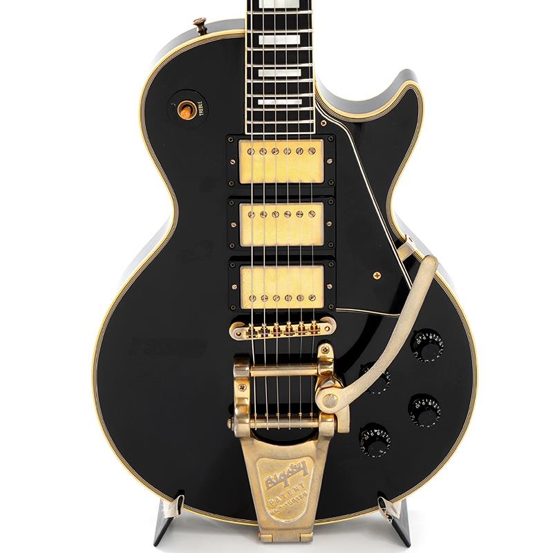 ■商品紹介お勧めプレイヤーズ・コンディション中古品！Les Paul Modelの最上位機種として位置づけられるLes Paul Customの3-Pickup+Bigsbyのフルスペック仕様がお勧めプレイヤーズ・コンディション中古品で入荷！2006年製です。漢（おとこ）達が選ぶギター、レスポールカスタム！スタンダードでは駄目だ！カスタムじゃなければ届かない！！そんな熱狂的なカスタムファンの声も聞かれる程に愛されるモデルが、Les Paul Customです！その精悍なルックスで多くのギタリストを魅了して止まない伝説のモデル1957 Les Paul Custom。今や市場でも稀少な状態が続いております。今回の入荷はオールマホガニー・ボディのHistoric Collection 1957 Les Paul Custom 3PU Bigsbyのお勧めプレイヤーズ・コンディション中古品です。1954年に登場したLes Paul Customは1957年頃よりハムバッカーピックアップ、通称PAFを搭載するようになります。3-Pickup+Bigsbyと同年代のギターを思わせるフルスペック仕様！こちらはピックアップは時期的にも3基共にBurst Buckerと推測されます。フロントPUのみBB＃1のステッカーがあり、センター＆リアもオリジナルだがステッカーなしでございますが、恐らくセンターもBB＃1でリアがBB＃2と推測されます。ゴールドカラーで揃えられたパーツ、多重のバインディングやダイヤモンドインレイは「タキシードに似合う」ギターと言われるだけの高級感と気品があります。1957年モデルのLes Paul Customは後年に発売される1968年、1974年モデルとは異なり、ボディはオールマホガニーとなります。メイプルトップのようなアタック感は少ないですが、オールマホガニーならではのふくよかで暖かみのあるトーンがこのモデルの特徴と言えます。ネックセクションはマホガニーネックにエボニー指板をセレクト。今や希少材となり非常に高価な値段で取引されているエボニー指板はスタンダードLPよりシャープ＆タイトなサウンドで、HM/HRらしくゲインを高めても音が潰れ過ぎず抜けが良い男性的なトーンを生み出します！ハードエッジに歪ませる方々にも人気を博しております。ペグにはグローバーをセレクト。ビグスビーがもたらす倍音感溢れる鳴りはアンサンブルの中でも効果を発揮致します！今でこそ、ぼっち・ざ・ろっく！旋風でロック女子が使うイメージも強い漆黒のエボニーカラーのLes Paul Customでございますが、昭和のイメージでいうと、レジェンドギタリスト、キース・リチャーズ師匠や、ジミー・ペイジ名人が初期に使用していた3ピックアックのLes Paul Customや、2ピックアップでは、めんたいロックの猛者達が使用するロックの神具でございました！！ミスターレスポールカスタムというべくの鮎川誠氏を筆頭に、THE MODS 苣木寛之氏、TH eROCKERS 谷信雄氏　等の猛者が豪快に弾きたおすギターが、エボニーカラーのLes Paul Customでございました！しかしながら平成、令和へと時代は変わり、黒いLes Paul Customも、様々な方々が使用するようになった事は、感慨深いものがございます。。今回、お勧めプレイヤーズ・コンディション中古品が入荷致しました！2006年製になります。全体に細かいスリ傷や幾つかの打痕、ボディバックのバックル傷、全体の塗装焼け、くすみ、ピックガードの弾き傷、ネックバインディング全体のクラック、ゴールドパーツのくすみ等は見受けられますが、雰囲気のある1本です！いずれもプレイアビリティには支障、問題ございません。当店にてフルメンテナンスとクリーニングを施しておりますので、すぐにご使用出来るお勧めの一本です。フレットはすり合わせ済です。現状のご使用は可能でございますがかなり低めです。約3割5分残りでございます。次回削れた際はリペアショップでのフレット交換をお勧め致します。ナットも現状のご使用に問題ございません。トラスロッドも通常の調整に問題ございません。（※フレット交換の際は合わせてのナット交換も必要となります。こちらの商品はネック周りは保証対象外とさせて頂きます。）電装系もフルチェックしておりますので、動作に問題ございません。ウェイトは約4.64kgです。重めではございますが、芯のあるサウンドを生み出すバランスです。付属品はオリジナルのブラック・ハードケースと鍵、シリアル入りタグ、日本語取扱説明書になります。認定証は欠品しております。3PU、Bigsbyを搭載した生産数の少ない1957 Les Paul Custom Reissueの中古品！是非、この機会をお見逃し無く！SN. 7 6561Weight≒4.64kg付属品　オリジナル・ブラック・ハードケース、鍵、シリアル入りタグ、日本語取扱説明書。認定証欠品。※こちらの商品はネックセクションは保証対象外とさせて頂きます。■仕様詳細BodyBody Material: 1-Piece Solid MahoganyBinding Style: Multi-plyNeckNeck Material: Solid MahoganyScale Length:24.75 / 62.865cmFingerboard Material: Solid EbonyFingerboard Radius: 12 / 304.8mmNumber of Frets: 22HardwareFinish: GoldBridge: ABR-1Tailpiece: BigsbyTuners: GroverPick Guard: Multiply Laminated AcrylicControl Knobs: Black Top HatsElectronicsNeck Pickup: Burst Bucker 1Middle Pickup: Burst Bucker 1(May be)Bridge Pickup: Burst Bucker 2(May be)※当店の取り扱い商品は中古の1点限りのご用意となります為、誠に勝手ながらご注文のお客様優先でのご案内とさせて頂きます。お問い合わせやお取置きのご依頼の際は予めご了承下さいますようお願い致します。イケベ楽器店Website以外の商品ページをご覧のお客様は、「取扱店舗の商品ページを見る」または「楽器店の購入ページへ」よりご注文下さい。検索キーワード：イケベカテゴリ_エレキギター_レスポールタイプ_Gibson_Custom Shop_ユーズド SW_Gibson_ユーズド JAN:2500010893770 登録日:2026/07/19 エレキギター ギブソン カスタムショップ