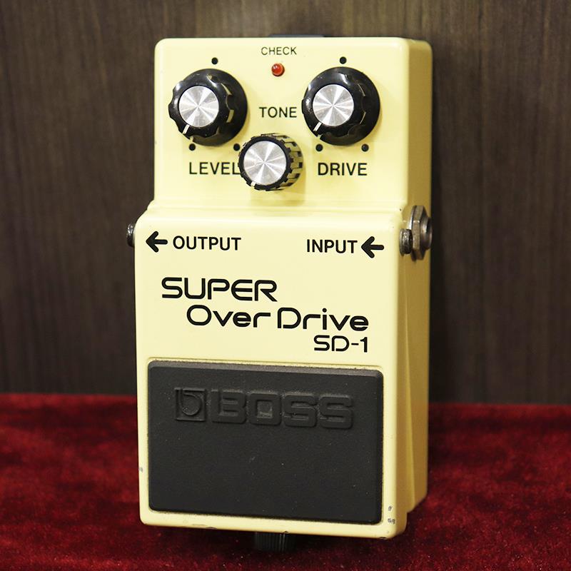 ■商品紹介OD-1の非対称クリップを継承しつつ、「TONE」ツマミを追加し発展させた『SD-1』。現在もラインナップが続く、Bossの名コンパクトエフェクターのひとつといえるでしょう。今回入荷は1986年頃の出荷と思われる1台。バックラベルに剥がれとゴム劣化、ペダルガイドブッシュ（止めねじ部分のゴム）の劣化がみられますが、筐体は細かなキズ程度で比較的きれいなコンディションではないでしょうか。オペアンプは、JRC4558DDを搭載。OD-1を継承したウォームで艶のあるナチュラルなオーバードライヴサウンドを基本にしつつ、トーンコントロールで幅を効かせた使いやすいサウンドが魅力です。付属品：なし※ACAアダプター対応モデルとなります-------Heartman Vintage Guitarsは池部楽器店のヴィンテージ・ギター＆ベースの専門店です-------検索キーワード：イケベカテゴリ_エフェクター_ギター用エフェクター_歪み系_オーバードライブ_BOSS_Distortion ／ Overdrive ／ Fuzz_ユーズド SW_BOSS_ユーズド 登録日:2026/02/27 エフェクター コンパクトエフェクター ストンプボックス ボス
