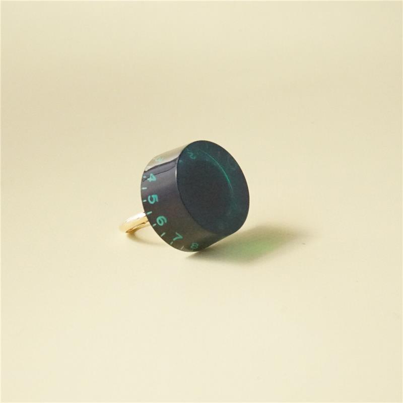 ■商品紹介■デザイン大好評の「ギターつまみリング」の文字色がカラフルになって登場！一番人気のブラックに、グリーンの数字が並び、POPさ増し増しです。ゴロッと大き目なサイズ感と一番人気のブラックで、どんな装いにも合わせやすい優れもの。リング部分は落ち着いたマットゴールドなので、重厚感だけでなく高級感もあります。それでいて、バンドマンだけに「！それって！」と刺さる、バンドマン探知機のようなアイテムなので、このリングがきっかけでバンドが組めちゃったりして。大き目モチーフのリングで、「音楽」も「かわいい」も存分にアピールしちゃいましょう！■サイズ・11号（フリー）・外寸　縦: 約3.5cm、横: 約2.5cm■注意事項＊こちらの商品は他ECサイトでも販売しております。在庫情報の更新は迅速を心掛けておりますが、万一ご注文時に売り切れていた際は、商品がご用意できない場合がございますのでご了承ください。＊画像の色味は屋内外の光の照射や角度により実物と異なって見える場合がございます。ご了承ください。＊輸入パーツのため、表面に細かい傷がついている場合がございます。それを踏まえたお値段設定になっています。＊一つ一つ手作りのため個体差がございます。検索キーワード：イケベカテゴリ_楽器アクセサリ_その他楽器アクセサリ_tsundrum_chan_新品 SW_tsundrum_chan_新品 JAN:4571642983410 登録日:2025/09/24 ツンドラムチャン ツン ドラム ちゃん kawaii かわいい カワイイ ハンドメイド 女子 大人かわいい ガールズ おしゃれ オシャレ お洒落