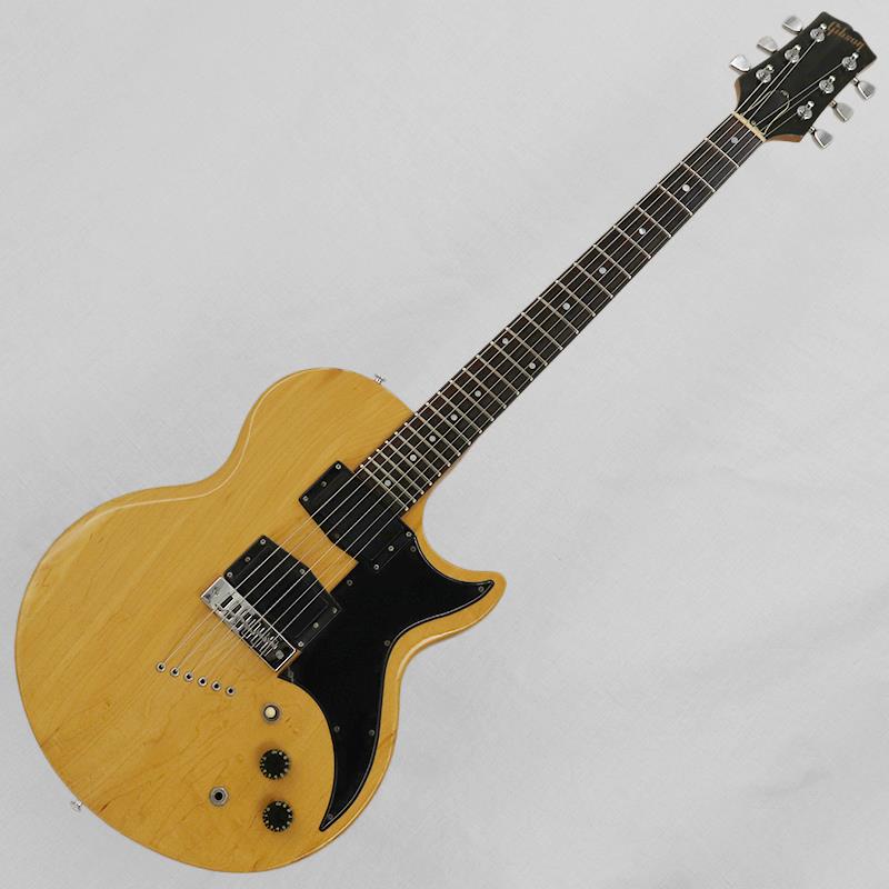 ■商品紹介1973年に発売された『L-6S』。ビル・ローレンス氏が開発したフェライトマグネットを使用したノンビジブルポールピースピックアップ「Super Humbucker（スーパーハムバッカー）」や6wayロータリーピックアップセレクタースイッチといった、当時では先鋭的な仕様が盛り込まれたモデルです。発売後バリエーションモデルも増えていきました。当時の錚々たるギタリストが使用していたことでもおなじみのモデルです。今回入荷はそのバリエーションモデルで、細部のルックス変更とロータリースイッチを省いた『L-6S Deluxe』。ナチュラルカラーの1本です。【ボディ】全体重量は約3.5kg。薄型のボディはメイプル3ピース材。グロストップのナチュラルカラーにブラックハードウェアという精悍なルックス。特徴的な裏通し仕様。角度によってギラっと浮き出る杢目が美しいですね。ボディ材ピースの境目のウェザーチェック、細かな打痕、ベルトバックル跡、ピックガードの割れ部分、パーツのくすみがみられますが、年式を考えると比較的きれいなコンディションといえるでしょう。【ネック】ネック材はメイプル3ピースのセットネック仕様。フィンガーボードはローズウッド24フレット仕様。ヘッドまわりのキズ、ネック裏の使用による塗装剥げ、金属パーツのくすみはみられますが、ボディ同様比較的きれいなコンディションではないでしょうか。チューナーは巻き具合も問題なくしっかりと機能します。フレット／ナットは多少減りがみられるものの、プレイアビリティは良好です。ナット幅40.1mm。比較的しっかりとしたネックシェイプといえるでしょう。【電装系】コントロールは【3wayピックアップセレクター／マスターボリューム／マスタートーン】となります。ピックアップはビル・ローレンス氏考案の「Super Humbucker」を2基搭載。ピックアップを含めコントロール系のパーツは当時のコンディションをキープしております。メイプルボディ／ネックならではのクリアなトーンに、Super Humbucker特有のレンジの広さと分離の良さが加わり、引き締まったタイトなサウンドが魅力です。クリアなクリーントーンから、ドライブ時には芯のある力強さを発揮し、シンプルなコントロールも相まって、ストレートなロックサウンドを中心に幅広く対応できるギターです。付属品：ノンオリジナルハードケース■仕様詳細Weight：3.9kgBody Material／Body Thickness：Maple 3 piece／ 32.0mmNeck Material／Scale Length：Maple 3 piece／628mm（24-3/4inch）Fingerboard／Fret Marker／Radius：Rosewood／Pearloid dot／254.0mm（10inch）Nut Width／Fret Size（width）：40.1mm／2.7mm， 24 FretNeck Thickness（1F／7F／12F）：21.0mm／23.5mm／24.9mmPickup（Neck／Bridge）：Gibson Super Humbucker for L-6S（5.85kΩ／5.85kΩ）※ピックアップの直流抵抗値はコントロール部を通した計測となります-------Heartman Vintage Guitarsは池部楽器店のヴィンテージ・ギター＆ベースの専門店です-------検索キーワード：イケベカテゴリ_エレキギター_その他_Gibson_Designer Models_ユーズド SW_Gibson_ユーズド JAN:2500010900089 登録日:2026/07/21 エレキギター ギブソン フライングブイ エクスプローラー