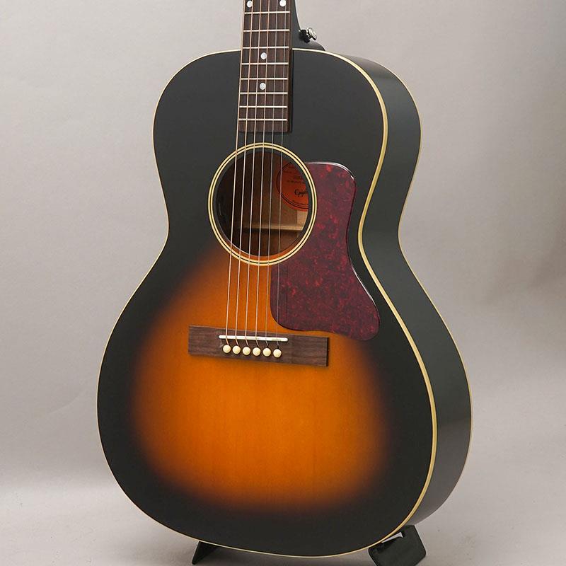 ■商品紹介ギブソンは1900年代初頭、L-Seriesスモールボディ・アコースティックギターの開発により、小型ボディ・ギターの分野における先駆者となりました。ギブソン L-00は1930年代初頭に開発され、数十年にわたりスモールボディ・ギターの業界標準モデルとして親しまれてきました。これらの小型モデルは、1934年のカタログで「完璧なバランスを備えたギター」と表現されたトーナリティを備えています。これらの小型ボディのL-Seriesギターは、家庭のリビングルームや応接室、いわゆる「パーラー(応接間・客間)」で演奏されることが多かったことからパーラー・ギターとも呼ばれ、現在に至るまで高い人気を維持しています。この度Epiphoneチームはギブソン・アコースティックとの緊密な連携によりL-00 Standardをリリースします。優れた演奏性とサウンドを備えた、本格的なパーラー・アコースティックを手の届きやすい価格で実現しました。初期ギブソン・モデルが持つ伝統を美しく受け継いでいます。Epiphone L-00 Standardはオール単板トーンウッドを採用しており、経年とともにサウンドがさらに成熟していきます。ボディのバックとサイドには単板マホガニーを採用し、単板スプルース・トップと組み合わせることで、ストローク演奏とフィンガースタイルの双方に適した、美しくバランスの取れたトーンを生み出します。カントリー、フォーク、ブルース、アメリカーナをはじめ、幅広いジャンルに対応します。ネックにはワンピース・マホガニーを採用し、快適なラウンデッドCプロファイルを備えています。ネックはテーパー加工されたダブテイル・ジョイントによるセットネック構造でボディに接合されています。指板には19本のスタンダード・フレットを装備し、控えめなマザー・オブ・パール製ドット・インレイを採用しています。人気の60s カラマズーシェイプ・ヘッドストックを採用し、ボーン・ナットと高品質なGrover Mini Rotomatic(R)チューナーを装備することで、安定したチューニング性能を実現しています。長方形のローズウッド・ブリッジにはボーン・サドルとアイボリー・プラスチック製ブリッジ・ピンを採用しています。Fishmanエレクトロニクスを搭載し、S-Coreアンダーサドル・ピックアップとFishman Presys VTプリアンプを装備しています。サウンドホール内に設置されたボリュームおよびトーン・コントロールは、演奏中でも素早く調整できる一方、観客からはほとんど視認されない設計となっています。■仕様詳細Shape | L-00Top | Solid SpruceBody | Solid MahoganyBinding | Single Ply， Top and BackNeck | One Piece MahoganyNeck Profile | Rounded CNut width | 1.69291 / 43mmFingerboard | RosewoodScale length | 24.75 / 628.65mmNumber of frets | 19Nut | BoneInlay | Mother of Pearl DotBridge | Rectangular， RosewoodTuners | Grover Mini RotomaticPlating | NickelUnder saddle pickup | Fishman S-CoreControls | Soundhole-mounted Volume and ToneCase | Premium Gig Bag検索キーワード：イケベカテゴリ_アコースティック・エレアコギター_エレアコギター_Epiphone_新品 SW_Epiphone_新品 JAN:4570156008060 登録日:2026/06/12 エレアコ エピフォン