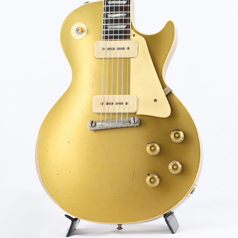■商品紹介All Goldの1954 Les Paul Standard Reissue Murphy Lab Heavy Agedが入荷致しました！当個体はGibson Lounge Tokyoでアーティストへの貸し出しなどに使用されていた個体となります。長きに亘り培われた高い製作技術と飽くなき探究心、厳選されたマテリアルにより至高のエレキギター・ベースを製作するために1993年に立ち上げられたGibson Custom Shop。現在もなお昔ながらのハンドクラフト製法と、徹底的に追求したヴィンテージの知識から製作されたカスタムショップ・ラインナップは、他所の追従を許さないほどの見事な作りとなり、プレイヤーの内に秘めるインスピレーションを際限なく沸き立たせてくれる最高の愛機となるでしょう。〜Murphy Labとは〜カスタムショップ内に誕生したMurphy Lab（マーフィー・ラボ）は、ナッシュヴィルのギブソン・カスタムショップ内に新設されたラボで、科学的検証に基づく最新の技術を駆使して、ギターのエイジング（ヴィンテージ・ギターの経時変化した外観と弾き心地を再現する処理）を専門に行います。ギブソン・カスタムショップの立ち上げ時のメンバーであり、ヒストリック・コレクション開発のプロジェクト・リーダーとして尽力したトム・マーフィーは、その後新品のギターにヴィンテージのルックスとフィーリングをもたらすエイジングというテクニックで活躍してきました。トムのヴィンテージ・ギターへの情熱と深い知識に裏打ちされた技術によって、ギブソン・ギターの自然なラッカーのクラック、演奏による摩耗を見事に再現しています。トム・マーフィーとギブソンは、経時変化によりウェザーチェックと呼ばれるクラックを生じさせる、1950年代、1960年代のニトロセルロースラッカーを科学的に解析し、その変化のプロセスをひも解き、あらゆるモデルのプロトタイプによるテストを重ねて、ヴィンテージ同様のナチュラル・ウェザーチェックを再現するラッカー・プロセスを開発しました。マーフィー・ラボは、トム・マーフィーがギブソン・カスタムショップのチームを率いて、プロトタイプをもとに、あらゆるボディシェイプ、フィニッシュ、エイジング・レベルの検証を始めたことから、その構想が生まれました。その結果、これまでにないリアリティとこだわりを追求したエイジングを行うために、ギブソン・カスタムショップ内に設立されました。トム・マーフィーの存在と、その芸術的な作品の数々は、ギブソンの歴史の中で重要な役割を果たし、今もそしてこれからもマーフィー・ラボとして永遠に引き継がれていきます。本機は4段階で設けられた中で3段階目（上から2番目）のエイジングレベルとなる「Heavy Aged」が施された1954 Les Paul Standard Reissueです。Heavy Agedはツアーやギグによるハードなプレイにより、ネックやボディのフィニッシュが剥がれた状態やベルトのバックル傷を再現。マーフィー・ラボによるヘビーエイジド・ハードウェアが採用されています。まるでオリジナルの1954 Les Paul Standard Reissueを手にしている様な感覚が味わえる、熟練したMurphy Labの職人たちの妙技が堪能できるエイジングが施されたモデルです。長年愛用され弾き込まれたようなリアルな塗装の色艶とウェザーチェックを表現。指板エッジにはロールド加工が施され、優れたグリップ感がプレイヤーの皆様にはさらに嬉しい仕上げとなっております。Double Goldと名づけられたゴールドカラーがフィニッシュされており、見る角度、光の当たり具合によって、渋さのある深緑から、明るいグリーンゴールドの色合いまでの変化が楽しめます。1954 Les Paul Standardを象徴する一つとしてラップアラウンドブリッジは独特のテンション感とバーブリッジ所以のダイレクトなサウンドがご堪能頂ける仕様となっております！またLower Logo（ヘッドのGibsonロゴが通常よりも低い位置にプレイス）を採用しており、マニアの心をくすぐる一品となっております。ウッドマテリアルに関しては、メイプル2PCトップにマホガニーバック、指板にはインディアン・ローズ指板と、オーセンティックなマテリアルをセレクト。3.96kgいうLes Paulらしい重量でどの音域もバランスよく出ている印象です。芳醇な生鳴りはアンプにプラグインする前から貴方を楽しませてくれるでしょう！通常の1954 Les Paul Standard Reissueは「50s Rounded Medium C-Shape」を採用しておりますが当モデルは59年仕様の「Authentic ’59 Medium C-Shape」を採用しており太すぎず細すぎず、現代的なプレイスタイルにも対応できる仕上がりとなっております。手のサイズ的に太目のネックシェイプを苦手とする方も多い傾向にある日本のユーザーの方々にも安心してお使い頂けます！サウンドの肝となるピックアップに関しては、P-90ピックアップ搭載により、ブルースやクラシックロックだけではなく、現代的なポップミュージックにもマッチしたサウンドをアウトプットしてくれます。本機の豊かなボディ鳴りがミックスされることで、アンプを選ぶこと無くクリーンサウンドではウェットで太く美しく。そしてゲインを上げたドライブサウンドでは自然な中域の膨らみとシングルコイル特有のバイト感の絶妙な融合により、至福の時間をお楽しみ頂けます。　 コントロールは2Vol、2Tone仕様にペーパーオイルコンデンサーを装備。ボリューム・カーブの効きは素早く8メモリ辺りからゲインが退き、手元の操作でクリーンサウンドからドライブサウンドまでを自在に操ることができます。トーン・コントロールに関しては、5メモリまではアタック感が残り、お好みのソリッド感を作ることが可能となります。オールドスタイルでありながらも、今もなお多くのミュージシャン達に愛され続ける54LP。ラップアラウンド・ブリッジがもたらす豊かなバイブレーション、倍音感、そしてGibsonの提唱するシングルコイルの極意。是非お手にとってご体感ください！！■仕様詳細■S/N: 4 5558■Weight≒3.96kgBodyBody Top: 2-Piece Plain Maple， Hide Glue FitBody Back: 1-Piece Lightweight MahoganyBinding: 1-Ply RoyaliteWeight Relief: NoneFinish: Nitrocellulose Lacquer; Murphy Lab Heavy AgedNeckNeck Material: Solid MahoganyProfile: Authentic ’59 Medium C-ShapeScale Length: 24.75 / 628.65mmFingerboard Material: Indian Rosewood， Hide Glue FitFingerboard Radius: 12Number Of Frets: 22Frets: Historic Medium-JumboNut Material: NylonNut Width: 1.69 / 42.85mmEnd of Board Width: 2.24 / 56.89mmInlays: Aged Cellulose Nitrate TrapezoidJoint: Long Tenon， Hide Glue FitHardwareFinish: Nickel; Murphy Lab Heavy AgedTuner Plating: NickelBridge: WraparoundTailpiece: WraparoundTuning Machines: Kluson Single Line， Single RingPickguard: Laminated Cellulose Acetate ButyrateControl Knobs: Gold Speed KnobsElectronicsNeck Pickup: Custom Soapbar P-90Bridge Pickup: Custom Soapbar P-90Controls: 2 Volume， 2 Tone， CTS 500K Audio Taper Potentiometers， Paper-in-Oil Capacitorsカスタムショップ・ブラウン・ハードケース、認定書他付属検索キーワード：イケベカテゴリ_エレキギター_レスポールタイプ_Gibson_Custom Shop_新品 SW_Gibson_新品 JAN:4570156015990 登録日:2026/04/03 エレキギター ギブソン カスタムショップ