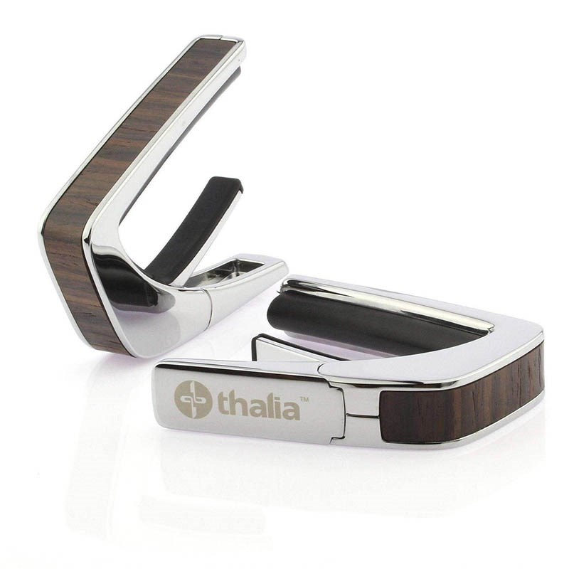 ■商品紹介これまでにないデザイン性と機能性に優れたカポタスト『Thalia Capos / タリア・カポ』。従来のカポとは一線を画す、見た目にも豪華なエキゾチック・ウッドやエキゾチック・シェル、彫刻や筐体のメッキ / フィニッシュ / カラーを採用したデザイン性に優れたモデルがあり、また、見た目のみならず機能面に関しても、通常のカポタストのように、使うギターの種類に合わせて1つずつカポを持ち替える必要がなく、フレットパッド(別売)をギターに合うものに交換するだけで簡単に、常にパーフェクトなテンション感とピッチ感で演奏する事を実現しました。フレットパッドのRには「0 for Classicals， 7.25， 9.5， 10， 12， 15， 16」の7種類があり、『スタンダード・テンション』と『ハイ・テンション』の計14種類。使用するギターや演奏に合わせてカスタマイズする事が可能です。・スタンダードテンション (弦に接するフレットパッド部分が標準的なモデル)・・・ 一般的なギター用・ハイテンション (弦に接するフレットパッド部分が厚いモデル)・・・ 薄いネック、12弦、ウクレレ、マンドリン、バンジョー用その他、握りこんで開く「リバース・アクション」機能が採用されており、1弦側からカポを取り付ける事で、演奏のポジションから手を返す事なくスムーズに指板上でカポを移動させる事を可能にします。Thalia Caposは様々な楽器に使用される事を想定しており、常に適切なテンション感で演奏していただけるよう全ての製品の内蔵スプリングの圧力が約7.5kgになるように、ひとつひとつ徹底した品質管理のもと製作されております。デザイン面、機能面、品質面、テンション感とピッチ感、すべてにおいてパーフェクトなカポタストです。※木目や貝模様は、天然素材を使用しているため個体により異なります。予めご了承ください。※パッケージ縮小に伴い、付属のフレッドパッドは12インチラディアス（Standard tension pad / High tension pad）2種類のみとなります。その他パッドをお求めの場合、別売にてご用意となります。検索キーワード：イケベカテゴリ_楽器アクセサリ_カポタスト_Thalia Capo_新品 SW_Thalia Capo_新品 JAN:4525421218484 登録日:2023/11/29 カポ カポタスト