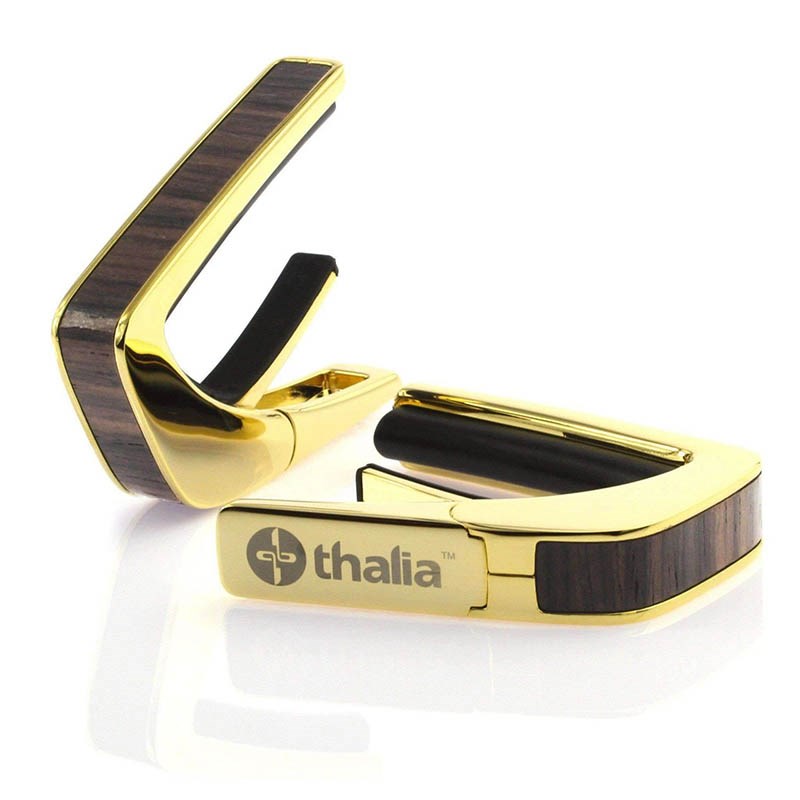 ■商品紹介これまでにないデザイン性と機能性に優れたカポタスト『Thalia Capos / タリア・カポ』。従来のカポとは一線を画す、見た目にも豪華なエキゾチック・ウッドやエキゾチック・シェル、彫刻や筐体のメッキ / フィニッシュ / カラーを採用したデザイン性に優れたモデルがあり、また、見た目のみならず機能面に関しても、通常のカポタストのように、使うギターの種類に合わせて1つずつカポを持ち替える必要がなく、フレットパッド(別売)をギターに合うものに交換するだけで簡単に、常にパーフェクトなテンション感とピッチ感で演奏する事を実現しました。フレットパッドのRには「0 for Classicals， 7.25， 9.5， 10， 12， 15， 16」の7種類があり、『スタンダード・テンション』と『ハイ・テンション』の計14種類。使用するギターや演奏に合わせてカスタマイズする事が可能です。・スタンダードテンション (弦に接するフレットパッド部分が標準的なモデル)・・・ 一般的なギター用・ハイテンション (弦に接するフレットパッド部分が厚いモデル)・・・ 薄いネック、12弦、ウクレレ、マンドリン、バンジョー用その他、握りこんで開く「リバース・アクション」機能が採用されており、1弦側からカポを取り付ける事で、演奏のポジションから手を返す事なくスムーズに指板上でカポを移動させる事を可能にします。Thalia Caposは様々な楽器に使用される事を想定しており、常に適切なテンション感で演奏していただけるよう全ての製品の内蔵スプリングの圧力が約7.5kgになるように、ひとつひとつ徹底した品質管理のもと製作されております。デザイン面、機能面、品質面、テンション感とピッチ感、すべてにおいてパーフェクトなカポタストです。※木目や貝模様は、天然素材を使用しているため個体により異なります。予めご了承ください。※パッケージ縮小に伴い、付属のフレッドパッドは12インチラディアス（Standard tension pad / High tension pad）2種類のみとなります。その他パッドをお求めの場合、別売にてご用意となります。検索キーワード：イケベカテゴリ_楽器アクセサリ_カポタスト_Thalia Capo_新品 SW_Thalia Capo_新品 JAN:4525421218507 登録日:2023/11/29 カポ カポタスト