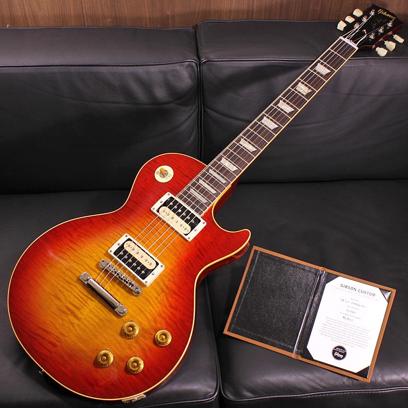 ■商品紹介Nashville Custom Shop Factoryでハンドセレクトしたトップ材を使用した1本が入荷！これぞ現地選定の醍醐味！標準的に1959 Les Paul Standardに使用されるフィギュアドメイプルよりもさらにハイグレードなトップ材をハンドセレクトしオーダーしたスペシャルなモデルが遂に入荷しました。「R-Top」と呼称されるゴージャスなフィギュアドを贅沢に味わい尽くしていただけるよう、ピックガードは敢えて装着せずに付属品としました。2箇所の穴開けは必要となりますがお好みで後からの装着も可能です。深みのある立体的に揺れるハイグレードなフィギュアドが貴方を甘美なバーストの世界へ誘います！エレキギター史に燦然と輝く1959 Les Paul Standard Model。数々のミュージシャンを虜にした圧倒的な存在感を放つサウンド、そして艶かしく弾き手を魅了する美しいボディラインは現代に於いても全てのロックギタリスト憧れのアイコンと言えるでしょう。1951年発売以来のゴールドトップ期を経て1958年にサンバーストフィニッシュを採用し、1960年までの僅かな期間にその姿で製作された「Les Paul Standard」。その中でも代表的年度として一際の人気を誇る「1959」モデルは常に羨望の眼差しを集める偉大な存在として君臨し続けております。そんな「1959」モデルを現在のGibson Custom Shopの技術の粋を結集し製作した一本です。究極のリイシューモデルとして2015年に登場したTrue Historicスペックを大部分で踏襲した2018年仕様をベースに、細部に亘りさらなる拘りを持って製作された2019年の60th Anniversaryモデルと同等スペックの最新入荷品です！60th Anniversaryモデルの発売時には、ギターのまさに「顔」とも呼ぶべきヘッドの「Les Paul MODEL」シルクスクリーンの色合いの見直しの他、Gibsonロゴデザインもよりオリジナルに近いデザインにリファイン。インレイは指板ポジションマークも含め、着色によるものではなく元々色合いの濃いセルロース素材を使用することで一層雰囲気を高めています。基本的なスペックは最新のHistoric Specを採用。アンポッテッドのCustombucker Alnico IIIピックアップやアップデートされたアッセンブリ、True Historicパーツが引き続き装備されております。ピッキングに鋭く追従する鋭敏なレスポンスは、ギターをアンプにプラグインしたその刹那からプレイヤーを魔法の様にレスポールトーンの虜にしてしまいます！トーンを絞った際の音抜け感の良さは勿論のこと、ヴォリュームを絞っても程良くブライトさがキープされるコントローラブルなアッセンブリーは現代的な使用方法とも素晴らしい相性を見せてくれるでしょう！！今回のオーダー品では出荷時にカバーは敢えて装着せずオープンゼブラとすることで、ルックス面でのインパクトとクリスピーなアタックが魅力的なサウンドを持たせました。ピックアップカバーは2基分付属致しますので両側or片側をお好みで取り付けることも可能です。ハンドセレクトトップ材を使用したモデルの中でも一際スペシャルな稀少オーダー品！ギラギラとした細めのフィギュアド杢がボディトップを覆ったかと思えば角度によっては穏やかな一面の表情で魅せたりと、自然が生み出す芸術的な表情がバーストファンの本能を呼び覚ます1本です。ぜひお早めにご検討下さい！Serial No. 9 6901Weight≒3.78kg専用ブラウンケース、カスタムショップ認定証、PUカバー、ピックガード 等 付属■仕様詳細Body Wood : Hand Selected 2-Piece Flame Maple Top (R-Top) & 1-Piece Lightweight MahoganyNeck : Solid Mahogany with Long Neck Tenon / 50s Rounded Medium C ShapeFingerboard : Indian RosewoodFrets : Historic Medium-Jumbo 22FretsPickups : Custombucker Alnico III (Unpotted)Controls : 2 volume 、2 tone 、3-way switchBridge / Tailpiece : ABR-1 non wire / Lightweight Tailpiece w/Long StudTuners : Kluson Single Line， Single RingHardware color : Nickel検索キーワード：イケベカテゴリ_エレキギター_レスポールタイプ_Gibson_Custom Shop_新品 SW_Gibson_新品 JAN:4570156010155 登録日:2026/08/05 エレキギター ギブソン カスタムショップ