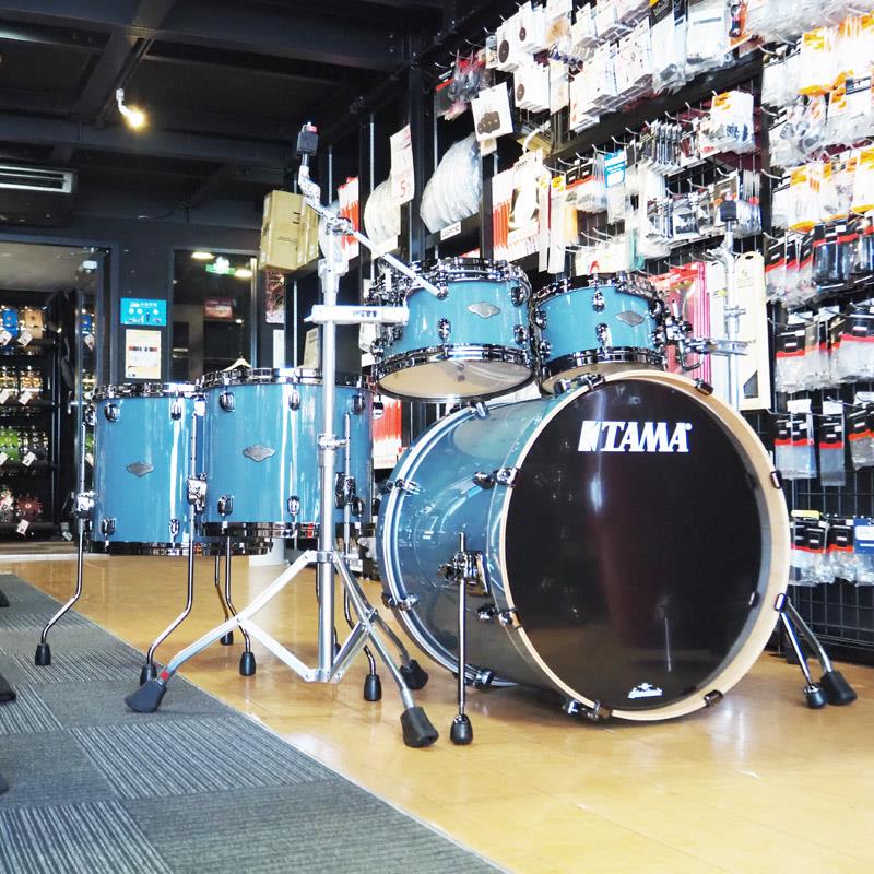 ■商品紹介【タマより各色4台の限定ドラムセットが発売！超浅胴''ハイパー・ドライブ''仕様のスター・クラシック・パフォーマー・キット！】STARCLASSIC PERFORMER 5pcs Kit / Hyper Drive Configuration & Black Nickel Shell Hardware-そのパワフルかつ表現力豊かなサウンドによって高く評価されているTAMA Starclassic Performerに、超浅胴仕様''ハイパー・ドライブ''サイズのタムをフィーチャーした限定モデルが登場します。超浅胴シェルが生み出す、パンチの効いたアタックと明瞭なトーン。浅さを生かしたセッティングの自由度。そしてタムタムを低い位置にもセットできることによるビジュアル的アピール力も特長です。シェルはメイプル バーチのハイブリッドシェル。ハードウェア面においても、Starclassicの看板でもあるStar Cast Mounting Systemを採用することで、Starclassicの持つ「優れたシェル鳴り」を継承しながらも時代のニーズに合わせたサウンドを提供します。フィニッシュには、遊び心とエレガントさを兼ね備えたピンクと、落ち着いた佇まいのモダンなグレーをラインナップ。ブラックニッケルパーツと組み合わせも抜群で、プレイヤーとオーディエンスの心をドライブさせる洗練されたルックスです。-Shells (Maple/Birch)-TT/FT : 6mm， 4ply Birch + 2inner ply MapleBD : 7mm， 5ply Birch + 2inner ply Mapleシェル材には、内側の2plyにメイプルを、外側にバーチを組み合わせたハイブリッドシェルを採用。メイプル材の持つウォームで音抜けの良いシェル鳴りに、バーチ材のはっきりした音像とソリッドなアタックを加えることで、バランスの取れたクリアでパンチのあるサウンドを実現します。-Hyper Drive Toms-10''x6.5''、12''x7''と、シェル鳴りが心地良いレゾナンスとパワー、そしてアタックの効いたキレの良さを両立するバランスを目指した超浅胴のタムサイズ。サウンドだけでなく、その浅さを活かしたセッティング自由度の高さも魅力です。-Die Cast Hoops-高い剛性を持つ亜鉛ダイキャスト製フープが、ヘッドとフープの接触面を常に垂直に保ちシビアなチューニングにも敏感に対応します。基音のはっきりしたパワーのあるサウンドも大きな魅力です。-Drum Heads-・TT/FT打面 : EVANS G1 Coatedボトム: TAMA オリジナル Power Craft II クリアヘッド・BD打面 : EVANS GENERA EQ4 Clearフロント: TAMA オリジナル黒ヘッド-Black Nickel Shell Hardware-限定シェルカラーを一段と引き締めるブラックニッケルハードウェアを採用しました。●MBS52HZBNS(シェルキット)内容22''x18'' バスドラム (タムホルダーベース無)10''×6.5'' タムタム12''x7'' タムタム14''x12'' フロアタム16''x14'' フロアタムMC69 シングルタムアタッチメント(×2)Color :スモーキー・グレー (SGR)※店頭展示、試打を解禁しております為、ヘッドに打痕がある場合がございます。予めご了承くださいませ。※本商品はスネアドラムを除くいた、シェルキットのみでの販売となります。また各ドラムは、スネアドラムを除き、単品での販売はございません。※タムアタッチメントを除き、写真のスタンド類・ペダル・シンバルは商品に含まれません。検索キーワード：イケベカテゴリ_ドラム_ドラムセット_TAMA_新品 SW_TAMA_新品 JAN:4549763378125 登録日:2026/05/05 ドラムセット ドラムキット タマ