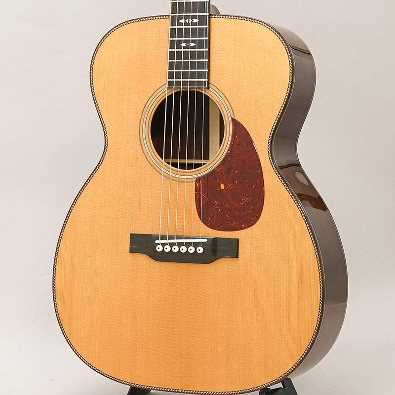 ■商品紹介- Bourgeois Guitars -ギター製作家「ダナ・ボジョア」が手掛けるBourgeois Guitars（ボジョアギターズ）は、コリングスやサンタクルーズと並び称されるアメリカのトップギターブランドです。厳選された材料と、確かな技術力、そしてダナ氏の豊富な経験から生まれる設計により製作されるギターは、「楽器としての精度の高さ」と「音楽的で豊かな音色」を併せ持ち、数多くのミュージシャンから高い評価を得ています。- Touchstone Series -Touchstone Series(タッチストーン・シリーズ)の魅力は、ダナ・ボジョアによるハンド・ヴォイシング・システム（材を叩いて音色を確認する、別名タップ・チューニング）にあります。過去50年にわたり、彼はこの古き良きテクニックを磨き上げ、現在では表板のヴォイシングの第一人者として世界的に認められております。世界最高級トーンウッドの繊維に秘められた潜在的な音色を読み取り、選りすぐりの表板が選別されています。それぞれの木材が持つ「音色」を最大限に引き出せるよう、表板の力木ひとつひとつを丹念に削り出し、ハンドヴォイシングをしながら音の確認を行います。タッチストーン・シリーズの表板が完成し、ダナによって最終チェックされた表板のみが真空密閉され、イーストマンの工房に出荷されます。そこでは、ボジョアの哲学と構造方法論を入念に学んだイーストマン選りすぐりのルシアーたちが、それぞれのギターに命を吹き込みます。本器は伝統的なボディスタイルに、ダナ・ボジョア氏のデザインセンスが光るSignatureと銘打たれたモデル。トリファイド加工が施されたシトカスプルーストップにアディロンダックスプルースブレーシング、マダガスカルローズウッドサイドバック、マホガニーネック、エボニー指板＆ブリッジ、シャーラーペグという大変贅沢なスペックとなっております。サウンドにおいても、オールUSAメイドのボジョアに劣りを見せない素晴らしい仕上がり。ボジョアらしい太く艶やかな基音とボリューム感のあるミッドレンジ、主張し過ぎることなく美しい余韻を演出する倍音と伸びやかなサスティーン。どれも絶妙なバランスで混ざり合っており、弾き手のニュアンスが引き立つ混じりけの無いピュアトーンを奏でます。サイドバックに希少材であるマダガスカルローズウッドを採用していることもあり、硬質で煌びやかでありながら独特の甘さを感じる上質な倍音が、ボジョアならではの前に音が飛んでいく基音に絶妙に絡み合う素晴らしい音色が大変魅力的なシリーズ。60万円台のというボジョアの中では大変お求めやすい価格帯のモデルとはなりますが、コストパフォーマンスという言葉で表してしまうのはもったいない程に、一切妥協のない造り込みで製作されており、圧倒的なサウンドクオリティを体感いただける楽器に仕上がっております。是非この機会にご体感くださいませ！！■仕様詳細Body Shap: OMTop Wood: Alaskan Sitka SpruceBack Sides:Madagascar RosewoodNeck: MahoganyFretboard: EbonyBridge: Ebony TraditionalScale Length: 25.5(647.7mm)Nut/Bridge Width: Nut-1 23/32(43.7mm) Bridge-2.2(55.8mm)Saddle: BoneTuners: Schaller Grand Tune NickelPins: IvoroidFinish: High GlossBracing: Adirondack Spruce検索キーワード：イケベカテゴリ_アコースティック・エレアコギター_アコースティックギター_Bourgeois_新品 SW_Bourgeois_新品 JAN:4582632727228 登録日:2026/03/02 アコースティックギター アコギ