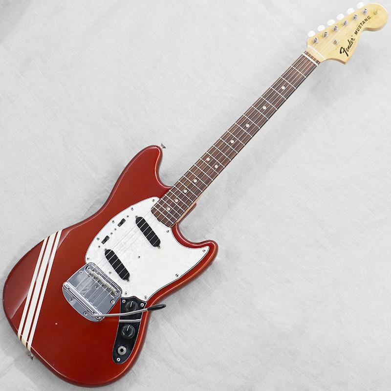 ■商品紹介1964年に登場し、現在もたいへん人気のある『Mustang（ムスタング）』。スチューデントモデルとしての立ち位置ながらもレギュラーモデルにも劣らぬウッドマテリアルやパーツによって、手軽にフェンダートーンを楽しめるギターとして人気を博しました。今回入荷は1972年頃の出荷品。1969年よりカタログに登場した『Competition Red with White Stripes（コンペティションレッド）』カラーの1本です。【ボディ】全体重量は約3.6kg。他の主要モデル同様に塗装は「Fender Thick-Skin High-Gloss（シックスキン）」フィニッシュが採用されます。メタリックレッドのボディにクリーム色のレーシングストライプが魅力のひとつです。ピックガードは塗装面との化学反応による接着がみられ現状は外れなくなっております。塗装剥げを伴う打痕等キズ、ピックガードの経年による縮み、金属パーツのくすみがみられ、比較的きれいながらもヴィンテージ楽器らしい雰囲気の良いコンディションとなります。アームバーが欠品となります。【ネック】ネック材はメイプル。フィンガーボード材はローズウッド。メイプルにはバーズアイ杢がみられ、特にヘッド付近を彩ります。ヘッドトップやネック裏に打痕がいくつか、金属パーツのくすみがみられ、ボディ同様比較的きれいなコンディションといえるでしょう。チューナーは2弦用のツマミに少々の曲がり、全体的に巻き具合の固さにバラつきはみられますが、しっかりと機能します。ローフレット近辺に減りがみられますが、現状極端な音詰まり等はございません。ヘッド厚15.9mm。ナット幅40.3mm。クセのない比較的しっかりとした厚みのネックシェイプが特徴です。【電装系】ムスタングおなじみのコントロールは【マスターボリューム／マスタートーン／各ピックアップセレクタースイッチ】。ピックアップセレクターのスイッチング次第でインフェイズ／アウトオブフェイズのミックスサウンドを作ることができるおなじみのコントロール。現状ピックガードが外せませんので、POT部のハンダを外した形跡がみられないことに着目しピックアップは当時のままと判断しています。楽器自体の鳴りも良好で、歯切れの良さと、オールドフェンダーらしい艶感と食いつき感のあるトーンが魅力です。付属ケース：Fenderシルバーハードケース■仕様詳細Weight：3.6kgNeck Material／Scale Length：Maple 1 piece／609.0mm（24inch）Fingerboard／Fret Marker／Radius：Rosewood round laminate／Pearloid dot， 22 Fret／184.15mm（7.25inch）Nut Width／Fret Size（width）：40.3mm／2.1mmNeck Thickness（1F／7F／12F）：22.3mm／22.3mm／22.5mmCapacitor：Dilectron CircleD 100VPickup（Neck／Bridge）：Fender Mustang Singlecoil（5.7kΩ／5.6kΩ）※ピックアップの直流抵抗値はコントロール部を通しての計測となります-------Heartman Vintage Guitarsは池部楽器店のヴィンテージ・ギター＆ベースの専門店です-------検索キーワード：イケベカテゴリ_エレキギター_MGタイプ_Fender USA_Other_ユーズド SW_Fender USA_ユーズド JAN:2500010803410 登録日:2025/12/10 エレキギター フェンダー ふぇんだー フェンダーUSA