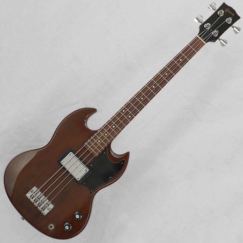 ■商品紹介厳選委託（お預かり代行販売）品Gibson（ギブソン）のエレクトリックベースの登場は1953年（このモデルは後にEB-1と呼ばれます）。ヴァイオリンシェイプやダブルカッタウェイのソリッドボディモデルからセミホローボディモデルまで、バリエーション豊かなラインナップで多くのベーシストから支持を得てきました。今回入荷は1972年ごろ出荷の1ピックアップ仕様の『EB-0』。1970年代の仕様が織り込まれた1本です。【ボディ】全体重量は約4.2kg。おなじみのSGシェイプのボディ材はマホガニー。1970年代の新しいボディはエルボーコンターやボディコンターが採用され、ピックアップの位置も中央寄りに配されています。オリジナルのチェリーカラー仕様ですが、褪色が進みぱっと見はマホガニーのブラウンカラー。キャビティ内やピックガード下にはチェリーカラーが鮮やかに残っています。ウェザーチェック、細かな打痕、金属パーツのくすみ等がみられ、ヴィンテージ楽器らしい素敵な雰囲気です。アウトプットジャック付近の木部ダメージは現在しっかりと補修されています。2弦3弦用のブリッジサドルオクターブビスが交換、その他ブリッジカバーは欠品しております。【ネック】ネック材はマホガニー3ピース。フィンガーボード材はローズウッド。30インチスケールに21フレット仕様となります。ヘッドまわりのやネックジョイント付近の継ぎ目のウェザーチェック、細かな打痕や塗装剥げ、金属パーツのくすみ等はみられますが、比較的きれいなコンディションといえるでしょう。チューナーの巻きの具合もそれほどバラつきはなくしっかりと機能します。フレット／ナットは少々の減り程度で、プレイアビリティは良好です。ナット幅は41.7mm。比較的しっかりとした握りのネックシェイプが特徴です。【電装系】コントロールはシンプルな【マスターボリューム／マスタートーン】。ピックアップはEBシリーズのオリジナルピックアップ。ピックアップの位置が旧仕様のネック寄りから、ボディ中央寄りに移動しているニューバージョンとなります。ボリュームPOTおよびトーンキャパシターは交換済みです。マホガニーボディと30インチスケール、そして大型のEBハムバッカーによる、太くふくよかなローミッドが魅力。ネック寄りの旧仕様と比べると、中央寄りに配置されたピックアップによって低域の輪郭がやや引き締まり、適度な中域の押し出しと音の芯を感じさせるサウンドに仕上がっています。指弾きでは太く粘りのあるトーン、ピック弾きでは程よいアタック感を伴った存在感のあるサウンドをお楽しみいただけるでしょう。※弦はショートスケール用をお選びください。付属品：Gibsonブラックチップボードケース■仕様詳細Weight：4.2kgBody Material：Mahogany 1 piece Neck Material／Scale Length：Maple 3 piece w/volute／770.0mm（30inch）Fingerboard／Fret Marker／Radius：Rosewood／Pearloid dot／304.8mm（12inch）Nut Width／Fret Size：41.7mm／2.5mm， 21 FretNeck Thickness（1F／7F／12F）：22.2mm／24.2mm／26.0mmTuner：Schaller M4S Bass Tuner， chrromePickup：Gibson EB Large Humbucker-------Heartman Vintage Guitarsは池部楽器店のヴィンテージ・ギター＆ベースの専門店です-------検索キーワード：イケベカテゴリ_ベース_エレキベース_その他ベース一般_Gibson_ユーズド SW_Gibson_ユーズド JAN:2500030919474 登録日:2026/08/23 エレキベース ギブソン ぎぶそん