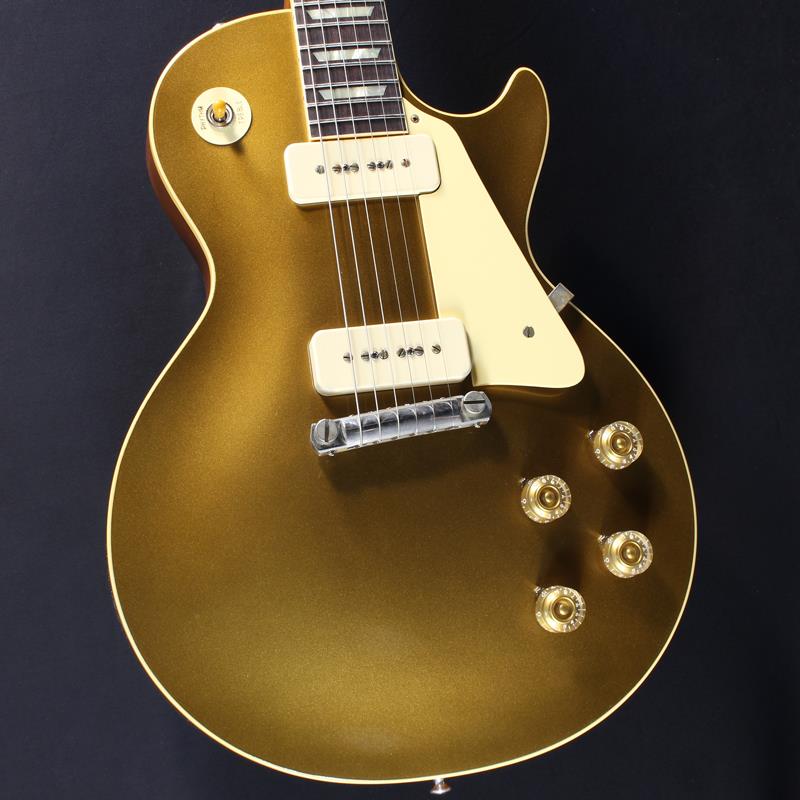 ■商品紹介1954 Les Paul Goldtop Reissueが入荷いたしました！長きに亘り培われた高い製作技術と飽くなき探究心、厳選されたマテリアルにより至高のエレキギター・ベースを製作するために1993年に立ち上げられたGibson Custom Shop。現在もなお昔ながらのハンドクラフト製法と、徹底的に追求したヴィンテージの知識から製作されたカスタムショップ・ラインナップは、他所の追従を許さないほどの見事な作りとなり、プレイヤーの内に秘めるインスピレーションを際限なく沸き立たせてくれる最高の愛機となるでしょう。昨今のGibson Cusotom ShopモデルというとMurphy Labによるエイジング加工が定番となっておりますが当モデルはVOS塗装となっておりウェザーチェックなどが入っていない艶を抑えたグロス仕上げとなっております。金属パーツはサビやくすみを再現しているためウェザーチェックやエイジング加工がお好みでない方には見逃せないオススメの一本となります。Double Goldと名づけられたゴールドカラーがフィニッシュされており、見る角度、光の当たり具合によって、渋さのある深緑から、明るいグリーンゴールドの色合いまでの変化が楽しめます。1954 LPを象徴する一つとしてラップアラウンドブリッジは独特のテンション感とバーブリッジ所以のダイレクトなサウンドがご堪能頂ける仕様となっております！ヘッドのGibsonロゴが通常よりも低い位置にプレイスされたLower Logoを採用しており、マニアの心をくすぐる一品となっております。ウッドマテリアルに関しては、メイプル2PCトップにマホガニーバック、指板にはインディアン・ローズ指板と、オーセンティックなマテリアルをセレクト。3.79kgというレスポールではやや軽量に部類される重量で、芳醇な生鳴りがアンプにプラグインする前から貴方を楽しませてくれるでしょう！ネックシェイプは現行のCustom Shop製品で最たる太さである「50s Rounded Medium C」。59LPに比べ肉付きのあるシェイプではありますが、所謂丸太の様なシェイプでは御座いません為、手のサイズ的に太目のネックシェイプを苦手とする方も多い傾向にある日本のユーザーの方々にも安心してお使い頂けます！サウンドの肝となるピックアップに関しては、P-90ピックアップ搭載により、ブルースやクラシックロックだけではなく、現代的なポップミュージックにもマッチしたサウンドをアウトプットしてくれます。本機の豊かなボディ鳴りがミックスされることで、アンプを選ぶこと無くクリーンサウンドではウェットで太く美しく。そしてゲインを上げたドライブサウンドでは自然な中域の膨らみとシングルコイル特有のバイト感の絶妙な融合により、至福の時間をお楽しみ頂けます。　コントロールは2Vol、2Tone仕様にペーパーオイルコンデンサーを装備。ボリューム・カーブの効きは素早く8メモリ辺りからゲインが退き、手元の操作でクリーンサウンドからドライブサウンドまでを自在に操ることができます。トーン・コントロールに関しては、5メモリまではアタック感が残り、お好みのソリッド感を作ることが可能となります。オールドスタイルでありながらも、今もなお多くのミュージシャン達に愛され続ける54LP。ラップアラウンド・ブリッジがもたらす豊かなバイブレーション、倍音感、そしてGibsonの提唱するシングルコイルの極意。是非お手にとってご体感ください！！約3.79kgハードケース付属■仕様詳細BodyTop Material: 2-Piece Plain Maple， Hide Glue FitBinding Style: 1-Ply RoyaliteWeight Relief: NoneFinish: Nitrocellulose VOS (Vintage Patina)NeckNeck Material: Solid MahoganyNeck Profile: 50s Rounded Medium CScale Length: 24.75 / 62.865cmFingerboard Material: Indian Rosewood， Hide Glue FitFingerboard Radius: 12 / 304.8mmNumber of Frets: 22Frets: Historic Gibson Narrow/TallNut Material: NylonNut Width: 1.687 / 42.85mmEnd-of-Board Width: 2.24 / 56.89mmInlays: Aged Cellulose Nitrate TrapezoidHardwareFinish: NickelBridge: WraparoundTailpiece: WraparoundTuners: Kluson Single Line， Single RingPick Guard: Laminated Cellulose Acetate ButyrateTruss Rod Cover: Authentic Stepped 2-PlyControl Knobs: Gold Speed KnobsSwitch Tip:Amber CatalinSwitch Washer: Silkscreened Cellulose Acetate ButyrateJack Plate: Laminated Cellulose Acetate ButyrateElectronicsNeck Pickup: Custom Soapbar P90Bridge Pickup: Custom Soapbar P90Controls: CTS 500K Audio Taper Potentiometers， Paper-in-Oil Capacitors検索キーワード：イケベカテゴリ_エレキギター_レスポールタイプ_Gibson_Custom Shop_新品 SW_Gibson_新品 JAN:4580228786109 登録日:2025/10/24 エレキギター ギブソン カスタムショップ