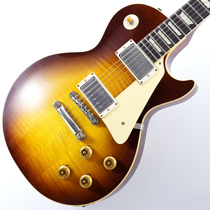 ■商品紹介King Of Les Paul！！ 1959 Les Paul Standard Reissue VOSが入荷！長きに亘り培われた高い製作技術と飽くなき探究心、厳選されたマテリアルにより至高のエレキギター・ベースを製作するために1993年に立ち上げられたGibson Custom Shop。現在もなお昔ながらのハンドクラフト製法と、徹底的に追求したヴィンテージの知識から製作されたカスタムショップ・ラインナップは、他所の追従を許さないほどの見事な作りとなり、プレイヤーの内に秘めるインスピレーションを際限なく沸き立たせてくれる最高の愛機となるでしょう。究極のリイシューモデルとして2015年に登場したTrue Historicスペックを大部分で踏襲した2018年仕様をベーシックに、細部に亘りさらなる拘りを持ってリファインされた最先端のカスタムショップ製Les Paul Standard。まさに「顔」とも呼ぶべきヘッドの「Les Paul MODEL」シルクスクリーンの色合いの見直しの他、Gibsonロゴデザインもよりオリジナルに近い、エッジ感のあるデザインに変更。インレイは指板ポジションマークも含め、着色によるものではなく元々色合いの濃いセルロース素材を使用することで一層雰囲気を高めています。1959 Les Paulならではの光の当たり方や角度で変化するボディの杢目と色合いはギブソンのゴールデンエラに作られたオールド独特のルックスとプレイフィールを再現しています。昨今の1959モデルというとMurphy Labによるエイジング加工が定番となっておりますが当モデルはVOS塗装となっておりウェザーチェックなどが入っていない艶を抑えたグロス仕上げとなっております。金属パーツはサビやくすみを再現しているためウェザーチェックやエイジング加工がお好みでない方には見逃せないオススメの一本となります。ネックシェイプは「Authentic '59 Medium C-Shape」を採用しており太すぎず細すぎず、現代的なプレイスタイルにも対応できる仕上がりとなっております。ピックアップは近年の定番モデルとなっているCustombucker Alnico IIIを継続して採用。キレのよいバイト感と個体がもたらす豊かなトーンバランスは本機でしか味わえない絶品サウンドをご体感頂けることでしょう。新たに搭載されたバンブルビータイプのペーパーオイルコンデンサーやヴィンテージカーブを追及した500KのCTSポットを装備。通常仕様の500kΩポットに比べてボリュームを絞っても極端に高域が削られず、手元の操作でクリーンサウンドからドライブサウンドまでを自在に操ることができます。10〜6のメモリまでは歪みが維持され、6〜1にかけて滑らかにダウンしていくので、ボリュームコントロールの長さによって表情豊かなプレイを可能にしています。細部にまでヴィンテージに拘りを持ったGibsonが送る最新スペックは、あなたのギターライフをより豊かにしてくれること間違い御座いません！！Weight≒4.08カスタムショップ・ブラウン・ハードケース、認定書他付属■仕様詳細Body:2PC Maple Top/Mahogany BackNeck:Mahogany w/Long TennonProfile: Authentic ’59 Medium C-ShapeFingerboard:RosewoodFrets:Historic Medium-JumboNut:NylonHardware:Nickel AgedBridge:No-Wire ABR-1 & Lightweight Aluminum TailpieceMachinehead:Kluson ReissuePickups:Custombucker Alnico III (Unpotted)Control:2Volume-2Tone-3way Toggle SW検索キーワード：イケベカテゴリ_エレキギター_レスポールタイプ_Gibson_Custom Shop_新品 SW_Gibson_新品 JAN:4580568415196 登録日:2026/03/27 エレキギター ギブソン カスタムショップ