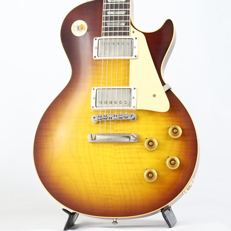 楽器種別：新品Gibson/Custom Shop 商品一覧＞＞Gibson/新品 商品一覧＞＞エレキギター【605，000円〜1，135，000円】 商品一覧＞＞レスポールタイプ/Gibson 商品一覧＞＞当店のギターは、出荷前に専門スタッフが検品・調整しているので安心です！Gibson 1959 Les Paul Standard Reissue VOS (Western Desert Fade) 【Weight≒3.94kg】商品説明2025年4月にNashville Custom Shop Factoryでハンドセレクトしたトップ材を使用した1本が入荷！セレクト材ならではのリッチな表情とWestern Desert Fadeフィニッシュによる激渋コンビネーションをぜひご堪能下さい！！長きに亘り培われた高い製作技術と飽くなき探究心、厳選されたマテリアルにより至高のエレキギター・ベースを製作するために1993年に立ち上げられたGibson Custom Shop。現在もなお昔ながらのハンドクラフト製法と、徹底的に追求したヴィンテージの知識から製作されたカスタムショップ・ラインナップは、他所の追従を許さないほどの見事な作りとなり、プレイヤーの内に秘めるインスピレーションを際限なく沸き立たせてくれる最高の愛機となるでしょう。究極のリイシューモデルとして細部に亘りさらなる拘りを持ってリファインされた最先端のカスタムショップ製Les Paul Standard。まさに「顔」とも呼ぶべきヘッドの「Les Paul MODEL」シルクスクリーンの色合いの見直しの他、Gibsonロゴデザインもよりオリジナルに近い、エッジ感のあるデザインに変更。インレイは指板ポジションマークも含め、着色によるものではなく元々色合いの濃いセルロース素材を使用することで一層雰囲気を高めています。昨今のGibson Cusotom ShopモデルというとMurphy Labによるエイジング加工が定番となっておりますが当モデルはVOS塗装となっておりウェザーチェックなどが入っていない艶を抑えたグロス仕上げとなっております。金属パーツはサビやくすみを再現しているためウェザーチェックやエイジング加工がお好みでない方には見逃せないオススメの一本となります。ハンドセレクト材とWestern Desert Fadeカラーの組み合わせが改めて1959 Les Paulの美しさを物語っている本機。1959 Les Paulならではの光の当たり方や角度で変化するボディの杢目と色合いはギブソンのゴールデンエラに作られたオールド独特のルックスとプレイフィールを再現しています。ネックシェイプは「Authentic '59 Medium C-Shape」を採用しており太すぎず細すぎず、現代的なプレイスタイルにも対応できる仕上がりとなっております。基本的なスペックは最新のHistoric Specを踏襲しつつも当モデルはアルニコ2のCustombuckerを採用。通常搭載されるアルニコ3のCustombuckerよりもやや出力は上がりますが豊かなサスティーンと程よいバイト感が心地よいサウンドを演出します。新たに搭載されたバンブルビータイプのペーパーオイルコンデンサーやヴィンテージカーブを追及した500KのCTSポットを装備。通常仕様の500kΩポットに比べてボリュームを絞っても極端に高域が削られず、手元の操作でクリーンサウンドからドライブサウンドまでを自在に操ることができます。10〜6のメモリまでは歪みが維持され、6〜1にかけて滑らかにダウンしていくので、ボリュームコントロールの長さによって表情豊かなプレイを可能にしています。細部にまでヴィンテージに拘りを持ったGibsonが送る最新スペックは、あなたのギターライフをより豊かにしてくれること間違い御座いません！！是非お手にとってご体感ください！！商品詳細■Weight≒3.94kg■S/N: 9 52341【SPEC】Body: Hand Selected 2-Piece Figured Maple Top & 1-Piece Lightweight MahoganyNeck: Solid MahoganyProfile: Authentic ’59 Medium C-ShapeFingerboard: Indian RosewoodFrets: Historic Medium-JumboNut: NylonHardware: Nickel Murphy Lab Light AgedBridge: No-Wire ABR-1 & Lightweight Aluminum TailpieceMachinehead: Kluson ReissueNeck Pickup: Custombucker Alnico 2 (Unpotted)Bridge Pickup: Custombucker Alnico 2 (Unpotted)Control: 2Volume-2Tone-3way Toggle SWカスタムショップ・ブラウン・ハードケース、認定書、他付属イケベカテゴリ_エレキギター_レスポールタイプ_Gibson_Custom Shop_新品 SW_Gibson_新品 JAN:4570156016416 登録日:2025/11/28 エレキギター ギブソン カスタムショップ