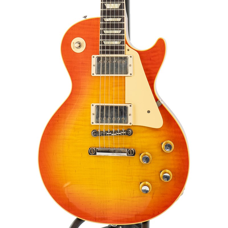 楽器種別：新品エレキギター/Gibson 商品一覧＞＞エレキギター/Gibson/Custom Shop 商品一覧＞＞エレキギター【505，000円〜950，000円】 商品一覧＞＞当店のギターは、出荷前に専門スタッフが検品・調整しているので安心です！Gibson 1960 Les Paul Standard Reissue Tangerine Burst VOS 【S/N 0 4128】商品説明テクニカル志向の方にも人気が高いスリムテーパーネック仕様！Gibson Custom Shop 1960 Les Paul Standardが入荷致しました！長きに亘り培われた高い製作技術と飽くなき探究心、厳選されたマテリアルにより至高のエレキギター・ベースを製作するために1993年に立ち上げられたGibson Custom Shop。現在もなお昔ながらのハンドクラフト製法と、徹底的に追求したヴィンテージの知識から製作されたカスタムショップ・ラインナップは、他所の追従を許さないほどの見事な作りとなり、プレイヤーの内に秘めるインスピレーションを際限なく沸き立たせてくれる最高の愛機となるでしょう。究極のリイシューモデルとして2015年に登場したTrue Historicスペックを大部分で踏襲した2018年仕様をベーシックに、細部に亘りさらなる拘りを持ってリファインされた最先端のカスタムショップ製Les Paul Standardの2023年モデルです！まさに「顔」とも呼ぶべきヘッドの「Les Paul MODEL」シルクスクリーンの色合いの見直しの他、Gibsonロゴデザインもよりオリジナルに近い、エッジ感のあるデザインに変更。インレイは指板ポジションマークも含め、着色によるものではなく元々色合いの濃いセルロース素材を使用することで一層雰囲気を高めています。そしてやはり1960 Les Paul最大の特徴と言えば1959 Les Paulよりもさらに薄く設計されたネックグリップでしょう。1959 Les Paulと比較すると意外なほど生産数が少なく実際に当店でも入荷は多くありませんが、実はプレイヤビリティーの良いスリムネックの60レスポールをお探しの方々も多いのではないでしょうかテクニカルなスタイルを求める腕利きプレイヤー好みの60レスポール特有のスリムネックシェイプはサウンド面にも影響を与えており、より歯切れが良くバンドアンサンブルの中でも抜群の存在感を醸し出す、エッジの効いたロック色の強いトーンを明瞭に弾き出します。ピックアップは近年の定番モデルとなっているCustombucker Alnico IIIを継続して採用しつつ、ポッティングをコイル部分、ベースプレートを含めた全面で廃し、新たに搭載されたバンブルビータイプのペーパーオイルコンデンサーやヴィンテージカーブを追及した500KのCTSポットを併せて装備することでより「剥き出し」な質感のヴィンテージフィール溢れるサウンドを実現しました。今まで以上にピッキングに鋭く追従する鋭敏なレスポンスは、ギターをアンプにプラグインしたその刹那からプレイヤーを魔法の様にレスポールトーンの虜にしてしまいます。トーンを絞った際の音抜け感の良さは勿論のこと、ヴォリュームを絞っても程良くブライトさがキープされるコントローラブルなアッセンブリーは現代的な使用方法とも素晴らしい相性を見せてくれるでしょう。さり気なくも美しいフィギュアドの一本です！VOSフィニッシュが風格を生み出しております。良質トップと良質バックマホガニーの組み合わせから弾き出されるサウンド・ハーモニーは至福の一時を与えてくれることでしょう！この機会を是非、お見逃し無く！※VOSシリーズはその仕上げ方の特性により、塗装/パーツ類にスクラッチや錆が元々から発生しておりますので予めご了承下さい。■Weight≒4.34kg■S/N:0 4128商品詳細【SPEC】Body: 2-Piece Figured Maple/1-Piece Lightweight Mahogany BackNeck: Solid MahoganyProfile: 1960 Slim TaperFingerboard: Indian RosewoodNut: NylonFrets: Authentic Medium-JumboHardwere: Nickel Light AgedBridge: No-Wire ABR-1 & Lightweight Aluminum TailpieceMachinehead: Kluson ReissuePickups: Custombucker Alnico III (Unpotted)Control: 2Volume-2Tone-3way Toggle SWイケベカテゴリ_ギター_エレキギター_Gibson_Custom Shop_新品 JAN:4580228787410 登録日:2024/04/08 エレキギター ギブソン カスタムショップ