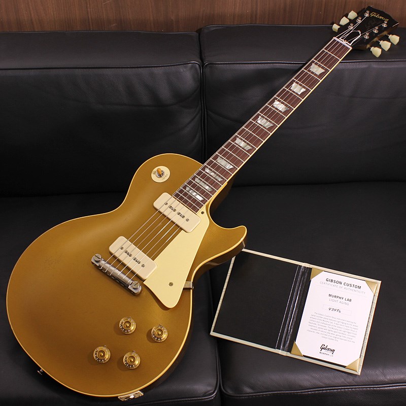 楽器種別：新品エレキギター/Gibson 商品一覧＞＞エレキギター/Gibson/Custom Shop 商品一覧＞＞エレキギター【580，000円〜1，090，000円】 商品一覧＞＞当店のギターは、出荷前に専門スタッフが検品・調整しているので安心です！Gibson Murphy Lab 1954 Les Paul Model Reissue All Gold Light Aged SN.4 3486商品説明日本限定オーダーの「All Gold」「Low Logo」を採用した1954 Les Paul Reissueが入荷！元々の生産数が少ない54LPモデルの限定品ですのでさらに見逃せません！P90ピックアップとラップアラウンドブリッジが生み出す唯一無二のゴールドトップトーンをぜひご堪能下さい。〜 Murphy Lab 〜カスタムショップ内に誕生したMurphy Lab（マーフィー・ラボ）は、ナッシュヴィルのギブソン・カスタムショップ内に新設されたラボで、科学的検証に基づく最新の技術を駆使して、ギターのエイジング（ヴィンテージ・ギターの経時変化した外観と弾き心地を再現する処理）を専門に行います。ギブソン・カスタムショップの立ち上げ時のメンバーであり、ヒストリック・コレクション開発のプロジェクト・リーダーとして尽力したトム・マーフィーは、その後新品のギターにヴィンテージのルックスとフィーリングをもたらすエイジングというテクニックで活躍してきました。トムのヴィンテージ・ギターへの情熱と深い知識に裏打ちされた技術によって、ギブソン・ギターの自然なラッカーのクラック、演奏による摩耗を見事に再現しています。トム・マーフィーとギブソンは、経時変化によりウェザーチェックと呼ばれるクラックを生じさせる、1950年代、1960年代のニトロセルロースラッカーを科学的に解析し、その変化のプロセスをひも解き、あらゆるモデルのプロトタイプによるテストを重ねて、ヴィンテージ同様のナチュラル・ウェザーチェックを再現するラッカー・プロセスを開発しました。マーフィー・ラボは、トム・マーフィーがギブソン・カスタムショップのチームを率いて、プロトタイプをもとに、あらゆるボディシェイプ、フィニッシュ、エイジング・レベルの検証を始めたことから、その構想が生まれました。その結果、これまでにないリアリティとこだわりを追求したエイジングを行うために、ギブソン・カスタムショップ内に設立されました。トム・マーフィーの存在と、その芸術的な作品の数々は、ギブソンの歴史の中で重要な役割を果たし、今もそしてこれからもマーフィー・ラボとして永遠に引き継がれていきます。本機は4段階で設けられた中で2番目に軽度なエイジングレベルとなる「Light Aged」が施された1954 Les Paul Gold Top Reissueです。1952年に誕生したレスポールモデルはギブソン社の歩みとともに変更される、ルックス、サウンド、弾き味などの仕様遍歴がございますが、本機は誕生当初のP-90ピックアップはそのままに、54モデルの最大の特徴と言えるラップアラウンドブリッジを搭載、オリジナルでもレアな「All Gold」フィニッシュを再現した日本限定オーダーのモデルとなっております。Light Agedは軽度の凹みや塗装剥がれ等のダメージ、リアルな塗装の色艶とウェザーチェックを表現。指板エッジにはロールド加工が施され、優れたグリップ感がプレイヤーの皆様にはさらに嬉しい仕上げとなっております。基本的なスペックは最新のHistoric Specを採用。54Les Paulの最大の特徴と言えるラップアラウンドブリッジならではの独特のテンション感が織り成す、軽快でありながら奔放な鳴りと、P90ピックアップの太くも表情豊かなニュアンスが生み出す音楽的なトーンはオンリーワンの魅力を備えており、本格派のミュージシャンの方々からも熱い支持を獲得しているモデルです！本機は日本からのオーダーでネックスペックに59LPと同様のグリップを採用し、通常の57LPネックよりもやや薄めでどなたでも握り易いスペックでオーダーされています。また、フレットサイズも現在のヒストリックモデルのスタンダード仕様では細めのフレットが使用されるところ、グリップと同様に59LPと同仕様のやや幅広なフレットサイズを採用しております。原点に回帰することでさらなる進化を続けるGibson Custom Shopの最新型の入荷です。Custom Shop製ならではの素晴らしいトーン、Murphy Labが生み出す迫力満点のエイジングをぜひご堪能下さい！Serial No. 4 3486Weight≒3.98kg専用ブラウンケース、Murphy Lab認定証 等付属商品詳細Body Wood : 2-Piece Plain Maple Top & 1-Piece Lightweight MahoganyNeck : Solid Mahogany with Long Neck Tenon / 50s Rounded Medium C ProfileFingerboard : Indian RosewoodFrets : Historic Medium-Jumbo 22FretsPickups: Custom Soapbar P-90Controls : 2 volume 、2 tone 、3-way switchBridge / Tailpiece : Lightweight Aluminum WraparoundTuners : Kluson Single Line， Single RingHard ware color : Nickel， Murphy Lab Light Agedイケベカテゴリ_ギター_エレキギター_Gibson_Custom Shop_新品 JAN:4570156001313 登録日:2023/11/27 エレキギター ギブソン カスタムショップ