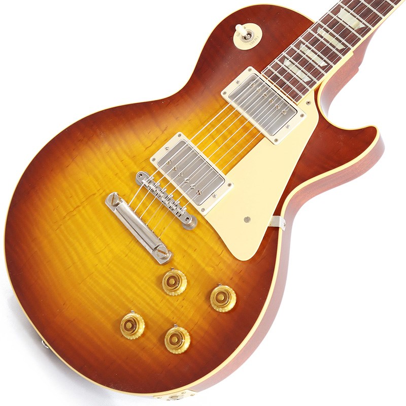 楽器種別：新品Gibson/Custom Shop 商品一覧＞＞Gibson/新品 商品一覧＞＞エレキギター【570，000円〜1，065，000円】 商品一覧＞＞レスポールタイプ/Gibson 商品一覧＞＞当店のギターは、出荷前に専門スタッフが検品・調整しているので安心です！Gibson 1959 Les Paul Standard Reissue VOS (Iced Tea Burst)【Weight≒4.10kg】商品説明King Of Les Paul！！ 1959 Les Paul Standard Reissue VOS Iced Tea Burstが入荷！長きに亘り培われた高い製作技術と飽くなき探究心、厳選されたマテリアルにより至高のエレキギター・ベースを製作するために1993年に立ち上げられたGibson Custom Shop。現在もなお昔ながらのハンドクラフト製法と、徹底的に追求したヴィンテージの知識から製作されたカスタムショップ・ラインナップは、他所の追従を許さないほどの見事な作りとなり、プレイヤーの内に秘めるインスピレーションを際限なく沸き立たせてくれる最高の愛機となるでしょう。究極のリイシューモデルとして2015年に登場したTrue Historicスペックを大部分で踏襲した2018年仕様をベーシックに、細部に亘りさらなる拘りを持ってリファインされた最先端のカスタムショップ製Les Paul Standard。まさに「顔」とも呼ぶべきヘッドの「Les Paul MODEL」シルクスクリーンの色合いの見直しの他、Gibsonロゴデザインもよりオリジナルに近い、エッジ感のあるデザインに変更。インレイは指板ポジションマークも含め、着色によるものではなく元々色合いの濃いセルロース素材を使用することで一層雰囲気を高めています。市場での人気が高いものの流通数の少ないIced Tea Burstカラーとの組み合わせが改めて59レスポールの美しさを物語っている本機。4.10kgというレスポールらしいずっしりとした重量を誇り、芳醇な生鳴りがアンプにプラグインする前から貴方を楽しませてくれるでしょう！1959 Les Paulならではの光の当たり方や角度で変化するボディの杢目と色合いはギブソンのゴールデンエラに作られたオールド独特のルックスとプレイフィールを再現しています。昨今の1959モデルというとMurphy Labによるエイジング加工が定番となっておりますが当モデルはVOS塗装となっておりウェザーチェックなどが入っていない艶を抑えたグロス仕上げとなっております。金属パーツはサビやくすみを再現しているためウェザーチェックやエイジング加工がお好みでない方には見逃せないオススメの一本となります。ネックシェイプは「Authentic '59 Medium C-Shape」を採用しており太すぎず細すぎず、現代的なプレイスタイルにも対応できる仕上がりとなっております。ピックアップは近年の定番モデルとなっているCustombucker Alnico IIIを継続して採用。キレのよいバイト感と個体がもたらす豊かなトーンバランスは本機でしか味わえない絶品サウンドをご体感頂けることでしょう。新たに搭載されたバンブルビータイプのペーパーオイルコンデンサーやヴィンテージカーブを追及した500KのCTSポットを装備。通常仕様の500kΩポットに比べてボリュームを絞っても極端に高域が削られず、手元の操作でクリーンサウンドからドライブサウンドまでを自在に操ることができます。10〜6のメモリまでは歪みが維持され、6〜1にかけて滑らかにダウンしていくので、ボリュームコントロールの長さによって表情豊かなプレイを可能にしています。4.10kgというウェイトから放たれる音はむっちりとした肉厚なサウンドでどの音域もよく鳴っている印象です。ディストーションサウンドから甘いクリーントーンまでこの1本で全てを網羅できると感じさせてくれるサウンドとなっております。細部にまでヴィンテージに拘りを持ったGibsonが送る最新スペックは、あなたのギターライフをより豊かにしてくれること間違い御座いません！！是非お手にとってご体感ください！！商品詳細■Weight≒4.10kg■S/N:9 32540【SPEC】Body:2PC Maple Top/Mahogany BackNeck:Mahogany w/Long TennonProfile: Authentic ’59 Medium C-ShapeFingerboard:RosewoodFrets:Historic Medium-JumboNut:NylonHardware:Nickel AgedBridge:No-Wire ABR-1 & Lightweight Aluminum TailpieceMachinehead:Kluson ReissuePickups:Custombucker Alnico III (Unpotted)Control:2Volume-2Tone-3way Toggle SWカスタムショップ・ブラウン・ハードケース、認定書他付属イケベカテゴリ_エレキギター_レスポールタイプ_Gibson_Custom Shop_新品 SW_Gibson_新品 JAN:4580568415196 登録日:2023/07/28 エレキギター ギブソン カスタムショップ