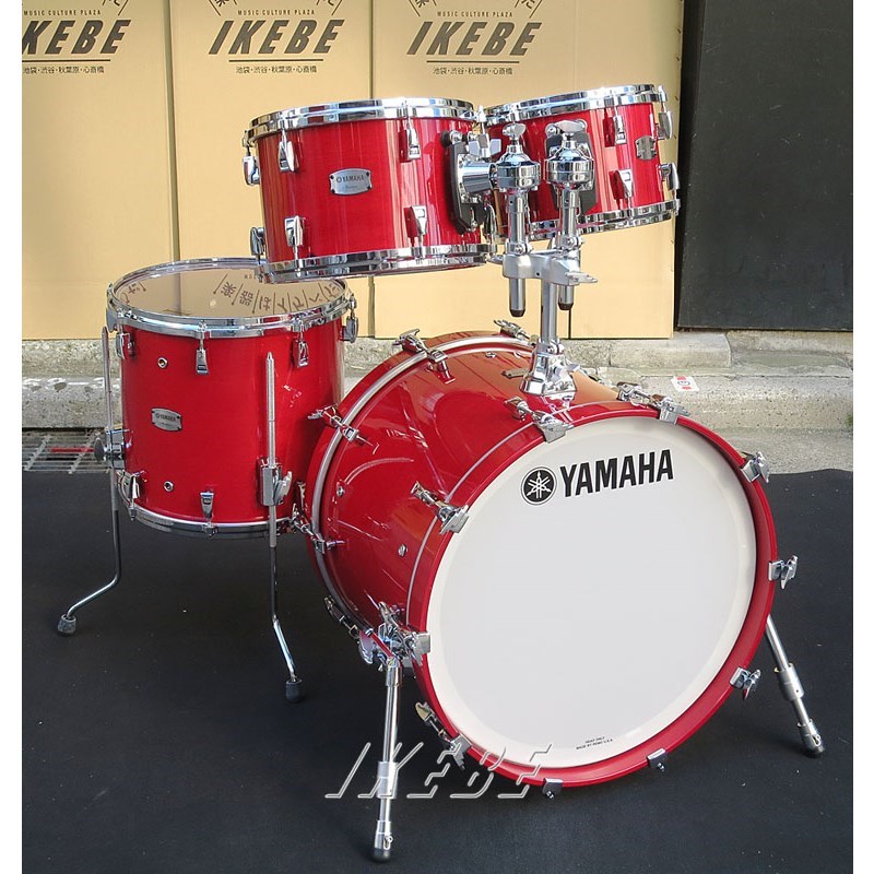 楽器種別：新品YAMAHA/新品 商品一覧＞＞ドラム【280，000円〜525，000円】 商品一覧＞＞ドラムセット/YAMAHA 商品一覧＞＞安心してお買い物頂けるよう、スネアもシンバルも丁寧梱包でお届けします！YAMAHA Absolute Hybrid Maple 4pc Drum Set - Red Autumn [AMP4F3 RAU ＋ AMB2016 RAU]商品説明Absolute Hybrid MapleAbsolute Hybrid Mapleは、プレーヤーが求めるサウンドを最大限に表現できることを追求したドラムです。最上位機種「PHX シリーズ」と同様の「ハイブリットシェル構造」を採用。「メイプル」をシェルの主材としながら芯材に「ウェンジ(Wenge)」を用いることで、従来のメイプルシェルのドラムでは表現できなかった豊かな倍音と幅広い音調を実現しました。タップからフルストローク、ピアニシモからフォルテシモまでしっかりと表現出来る輪郭のあるサウンドにより、幅広いジャンルの音楽への適応性と演奏性の高さを実現しています。サウンド・ルックスともにプレーヤーの独自性を表現することを可能にした、ドラマーのニーズを最大限満たすことができるドラム・シリーズです。＜主な特長＞1：「ハイブリットシェル構造」によるパワフルでセンシティブなサウンド最上位機種「PHX シリーズ」と同様の「ハイブリットシェル構造」を採用することにより、抜群のワイドレンジとサウンドレスポンスを追求しました。硬く重厚な特性を備えたアフリカ産の木材「ウェンジ」を芯材として配し、その両側を「メイプル」で挟み込むシェル構成としています。フロアタム/タムタムは、メイプル3 プライ＋ウェンジ1 プライ＋メイプル3 プライの7 プライ構成でベアリングエッジ加工に45゜/R1.5 を採用し、深みと低音感のあるサウンドを得ています。一方、バスドラムには、同様の7 プライ構成でありながら異なる厚さのプライを用い、ベアリングエッジ加工を30゜/R1.5 とすることで、ドラムセット全体のサウンドバランスを最適化しています。メイプル本来の特長である、明るくぬくもりのある鳴りと抜けの良いサウンドはそのままに、芯材であるウェンジの特長による芯のある力強いサウンド、どっしりとした中低域音感が加わり、クリアでアタック感のあるサウンド、素早い立ち上がりと豊かなサステイン、重厚な低音感まで得られます。このように、メイプルの特長を備えながらメイプルでは得られない独自のサウンドも備えた、表現力豊かなドラムセットを実現しました。2：シェルのポテンシャルを最大限に引き出すハードウェア「ハイブリットシェル構造」によるシェルが持つ本来のサウンドを最大限に引き出すため、使用するハードウェアも最適なものを採用しました。バスドラムに備えられるタムホルダーベースは、シェルとの設置面積を最小限に抑えた軽量なデザインとし、バスドラムの鳴りを最大限に保持します。フロアタムブラケットには、オープンタイプを採用し、高さ調整と適度な余韻のコントロールを両立させています。フロアタム/タムタムには3.0mm のアルミダイキャストフープ採用、そして全てのシェルに「PHX シリーズ」で使用している「フックラグ」を採用しました。ラグの接地面をできる限り少なくすることによりシェル鳴りを最大限に引き出すことができ、音質面へのこだわりとチューニングの正確性を高い次元で両立しただけでなく、素早いヘッド交換を可能にしています。さらに、新設計のタムマウント「Y.E.S.S.III」を採用、従来のY.E.S.S.IIと比べ金属製のパーツを少なくすることにより共振周波数を5％低減、タムタムのシェル鳴りを向上させました。＜セット内容＞●AMB201620×16 Bass Drum●AMP4F314×13 Floor Tom12×8 Tom Tom10×7 Tom TomDouble Tom Holder (TH945B)＜スペック＞【バスドラム】シェル：メイプル・ウェンジ・メイプル ハイブリッドシェル/7ply 8mm（内面VN 塗装）エアホール：10エッジ角：30°/ R1.5ラグ・ブラケット：フックラグ（クローム）フープ：ウッドフープヘッド：トップ ヤマハレモ P3 / フロント ヤマハレモ P3【フロアタム】シェル：メイプル・ウェンジ・メイプル ハイブリッドシェル/7ply 6.2mm（内面VN 塗装）エアホール：6エッジ角：45°/ R1.5ラグ・ブラケット：フックラグ（クローム）フープ：アルミダイカスト3.0mmヘッド：トップ ヤマハレモ エンペラークリア / ボトム ヤマハレモ アンバサダクリアフロアタムブラケット：オープンタイプ【タムタム】シェル：メイプル・ウェンジ・メイプル ハイブリッドシェル/7ply 6.2mm（内面VN 塗装）エアホール：1エッジ角：45°/ R1.5ラグ・ブラケット：フックラグ（クローム）フープ：アルミダイカスト3.0mmヘッド：トップ ヤマハレモ エンペラークリア / ボトム ヤマハレモ アンバサダクリアタムマウント：Y.E.S.S. III商品詳細＜セット内容＞●AMB201620×16 Bass Drum●AMP4F314×13 Floor Tom12×8 Tom Tom10×7 Tom TomDouble Tom Holder (TH945B)＜スペック＞【バスドラム】シェル：メイプル・ウェンジ・メイプル ハイブリッドシェル/7ply 8mm（内面VN 塗装）エアホール：10エッジ角：30°/ R1.5ラグ・ブラケット：フックラグ（クローム）フープ：ウッドフープヘッド：トップ ヤマハレモ P3 / フロント ヤマハレモ P3【フロアタム】シェル：メイプル・ウェンジ・メイプル ハイブリッドシェル/7ply 6.2mm（内面VN 塗装）エアホール：6エッジ角：45°/ R1.5ラグ・ブラケット：フックラグ（クローム）フープ：アルミダイカスト3.0mmヘッド：トップ ヤマハレモ エンペラークリア / ボトム ヤマハレモ アンバサダクリアフロアタムブラケット：オープンタイプ【タムタム】シェル：メイプル・ウェンジ・メイプル ハイブリッドシェル/7ply 6.2mm（内面VN 塗装）エアホール：1エッジ角：45°/ R1.5ラグ・ブラケット：フックラグ（クローム）フープ：アルミダイカスト3.0mmヘッド：トップ ヤマハレモ エンペラークリア / ボトム ヤマハレモ アンバサダクリアタムマウント：Y.E.S.S. III※店頭にて展示、試打を解禁しております為、細かい傷や汚れ、打痕等が発生する場合がございます。予めご了承くださいませ。イケベカテゴリ_ドラム_ドラムセット_YAMAHA_新品 SW_YAMAHA_新品 登録日:2022/01/18 ドラムセット ドラムキット ヤマハ やまは