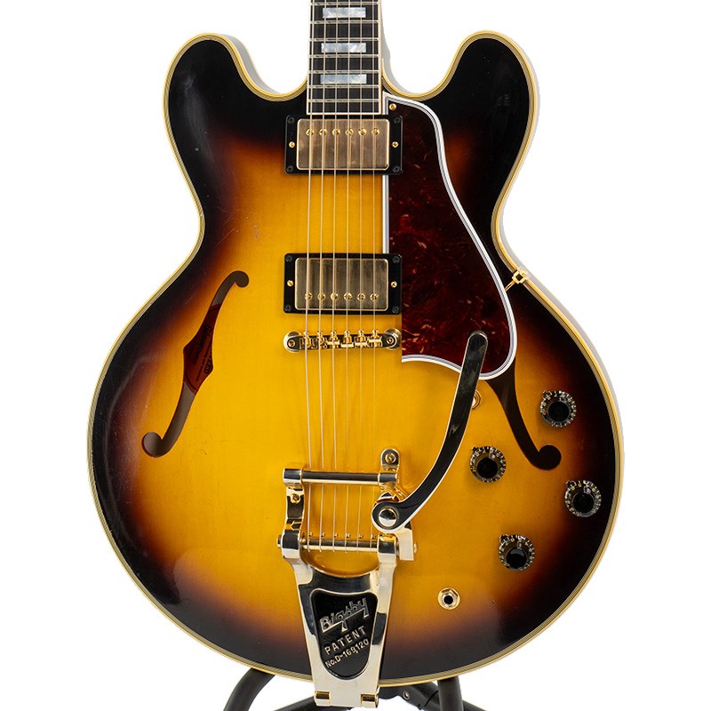 楽器種別：新品Gibson/Custom Shop 商品一覧＞＞Gibson/新品 商品一覧＞＞エレキギター【755，000円〜1，415，000円】 商品一覧＞＞セミアコ/Gibson 商品一覧＞＞当店のギターは、出荷前に専門スタッフが検品・調整しているので安心です！Gibson Murphy Lab 1959 ES-355 Bigsby Vintage Wide Burst Light Aged【S/N A930775】【TOTE BAG PRESENT CAMPAIGN】商品説明ロックの王者達を満足させるモデル、ES-355！見る方の気持ちを高揚させる、イケベ渾身の「 Pre Sold Limited （PSL）」オーダーモデル！話題沸騰のMurphy Labによるリアルなエイジングが施された極上のオーダーモデルが入荷です！風格たっぷりのVintage (Wide) Burstカラーが施された、1959 ES-355 Bigsby Vintage Wide Burst Light Agedが入荷です！Bigsby B-7も兼ね備えた王者の佇まいをお見逃し無く！！今回の入荷は、皆様の心を擽る魅惑のアイデアが満載した、イケベ渾身の「 Pre Sold Limited （PSL）」オーダーモデル！トップミュージシャン達に愛用される魅惑のES-355！ロックの『ボス』K.R氏の近年のメインギターもES-355ですね！今回、それに勝るとも劣らずの風格を兼ね備えた、魅惑のオーダーモデルがイケベに入荷です！ES-355のこの激渋ながらもビビットでロックなルックスは、ステージで脚光を浴びる事間違い無しでしょう！ES-355はES-335のアップグレード・モデルとしてリリースされました。「ES」シリーズもギブソン・ソリッド・シリーズの流れを組むラインナップ構成がされており、当機はLes Paulで言うところのアップグレード・モデル「カスタム」的な位置付けがされ、「カスタム」特有のスペックを採用している点が特徴となっております。スプリット・ダイアモンド・インレイが施されたラージマルチ・プライ・セル・バインディング、ゴールドパーツの採用等、上位機種らしい豪華さを兼ね備えており、レギュラーESシリーズに比べても圧倒的に重厚な高級感を醸し出しております。ロック好きの方が待ち望んだこのスタイル。Gibson Custom Shopによる逸品が、拘りオーダーモデルで入荷致しました！ヴァリトン・SWも無しでアッセンブリーもモノラル仕様を採用し、直ぐにステージに立てる様に仕上げられています！サウンドはボディウェイトを活かした低域の張りが特徴的、深みのあるナチュラル・ロック・サウンドを生み出します。激渋のVintage Wide Burstカラーが映えまくる逸品！更にはBigsby B-7も兼ね備えた、ロッキッシュさ極まる極上品です！Bigsbyがもたらす倍音感が、ミュージシャン達を魅了致します！ゴールド・ハードウェアが豪華さを彩ります！ウエイトは約4.09Kgです。芯のあるサウンドをご堪能頂けるバランスです。ロールドバインディングされた弾き易いネックには、今や希少なエボニー指板を使用。355に使用されるエボニー指板は、335よりシャープ＆タイトなサウンドで、ゲインを高めても音が潰れ過ぎず抜けが良い男性的なトーンを生み出します！ナッシュビル・ファクトリーならではのフレット処理の良さがプレイヤリティを高めております。ES-355王道のGroverペグが、チューニングの安定度を約束致します！ピックアップはCustombucker Alnico IIIを採用。ポッティングをコイル部分、ベースプレートを含めた全面で廃し、新たに搭載されたバンブルビータイプのペーパーオイルコンデンサーやヴィンテージカーブを追及した500KのCTSポットを併せて装備することでより「剥き出し」な質感のヴィンテージフィール溢れるサウンドを実現しました。今まで以上にピッキングに鋭く追従する鋭敏なレスポンスは、ギターをアンプにプラグインしたその刹那からプレイヤーを魔法の様にES-335トーンの虜にしてしまいます。トーンを絞った際の音抜け感の良さは勿論のこと、ヴォリュームを絞っても程良くブライトさがキープされるコントローラブルなアッセンブリーは現代的な使用方法とも素晴らしい相性を見せてくれます！トーンボリュームの反応が緩やかで手元の操作だけでもあらゆるトーンを生み出してくれることでしょう。更に特筆すべきは全体に施された歴史を再現したようなMurphy Labによるリアルなエイジング加工でしょう！本機は4段階で設けられたエイジングレベルで2段階目の「Light Aged」が施されています。さり気なくも、リアルなエイジング処理が全体に施されております！従来の方法とは違ったエイジングは自然な風合いのウェザーチェックとなり、トップはもちろんバック、ネックまでも経年変化を感じられる仕様。あたかも長く連れ添ってきたかと錯覚させられる「本物」を彷彿とさせるヴィジュアルです。ES-335と同じく、355もブルージーかつ大人の雰囲気を合わせ持ったギターですが、実はクリーン・クランチはもちろん、ハイゲインに歪ましてもしっかりと受けとめてくれる、オールマイティな懐の深いギターです。芳醇なボディ鳴りをリニアに受け止めてくれる弾き易くもしっかりとしたネック・シェイプにブロックポジションマーク。グローヴァー・ペグ・セレクトです。粋なスーパースターが手にするべき一本を是非、貴方に！S/N A930775Weight≒4.09kg商品詳細Body : 3-Ply Maple/Poplar/MapleNeck : Solid MahoganyFingerboard : Ebony 22frets Scale Length : 24.75Nut Width : 1 11/16Bridge : ABR-1/ Bigsby B-7 Grazed Black Enamel Machine Head : Grover Kidney - Milk BottleHardware : GoldPickups : Custombucker Alnico III (Unpotted)Controls : 2 Volume 、2 Tone 、3-way selector switchイケベカテゴリ_エレキギター_セミアコ_Gibson_Custom Shop_新品 SW_Gibson_新品 JAN:4570155998867 登録日:2023/10/15 エレキギター ギブソン カスタムショップ