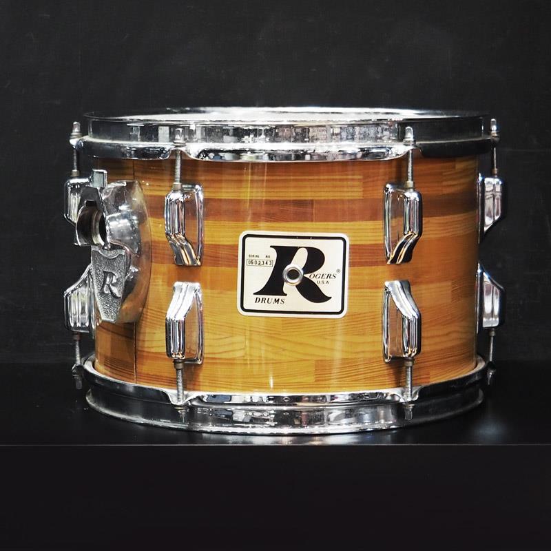 楽器種別：ヴィンテージRogers/ユーズド 商品一覧＞＞ドラム【10，000円〜30，000円】 商品一覧＞＞ドラムセット/Rogers 商品一覧＞＞安心してお買い物頂けるよう、スネアもシンバルも丁寧梱包でお届けします！Rogers VINTAGE 70s〜80s 12×8 TomTom/Butcher Block商品説明【1970年代中期〜80年製と思われるロジャースの12インチタムが入荷しました！】-Rogers Drums-アメリカのカーフスキン製ドラムヘッドメーカーとして1849年に創業したRogers Drumsは、1930年代頃からドラムの製造を開始しました。先鋭的なドラム製作技術やハードウェアを世に送り出し、特に1950年代半ばから1970年代頃にかけて大きく躍進し、アメリカのドラムメーカーの中心的存在となっていました。その優れたサウンドと機能性はジャズからクラシックロック、バディ・リッチをはじめとするビッグバンド・ドラマーまで幅広いジャンルのドラマーに愛用されています。スネアドラムにおいては、斬新なスネアイヤー張力調整機構を搭載した「Dyna-Sonic」はRogersの優れた機構設計技術を象徴するモデルとして知られており、また、当時としては非常に革新的なアイデアが盛り込まれた「Swiv-o-Matic」シリーズ・ハードウェアはリンゴ・スター、ジョン・ボーナム、キース・ムーンなど多くのトップ・アーティストがキットに採用していました。こちらは1970年代中期〜80年製と思われる12インチタム。ロジャースらしい非常に力強いアタックと図太いサスティンでいなたさを残しつつも音が塊で飛んでいくようなサウンド。バンドアンサンブルの中でも埋もれずに存在感を発揮することが出来ます。＜スペック＞シェル：5プライウッド＋レインフォースメント(内面ゾラコート)バッジ：ビッグRバッジ口径×深さ：12インチ×深さ8インチフィニッシュ：Butcher Block※ヴィンテージ品の為、年代相応の傷や汚れ、サビ、などがございます。予めご了承くださいませ。イケベカテゴリ_ドラム_ドラムセット_Rogers_ユーズド SW_Rogers_ユーズド JAN:2500190799732 登録日:2026/03/09 ドラムセット ドラムキット ロジャース
