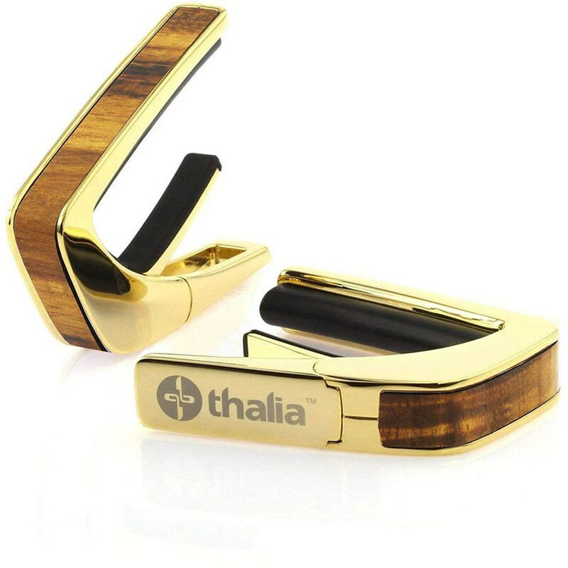 楽器種別：新品Thalia Capo/新品 商品一覧＞＞楽器アクセサリ【5，000円〜15，000円】 商品一覧＞＞カポタスト/Thalia Capo 商品一覧＞＞品揃え豊富な当店なら弦、パーツ、ケーブルなどのアクセサリーがまとめて揃います！Thalia Capo Exotic Wood Series 24K Gold Hawaiian Koa [新仕様] タリアカポ商品説明これまでにないデザイン性と機能性に優れたカポタスト『Thalia Capos / タリア・カポ』。従来のカポとは一線を画す、見た目にも豪華なエキゾチック・ウッドやエキゾチック・シェル、彫刻や筐体のメッキ / フィニッシュ / カラーを採用したデザイン性に優れたモデルがあり、また、見た目のみならず機能面に関しても、通常のカポタストのように、使うギターの種類に合わせて1つずつカポを持ち替える必要がなく、フレットパッド(別売)をギターに合うものに交換するだけで簡単に、常にパーフェクトなテンション感とピッチ感で演奏する事を実現しました。フレットパッドのRには「0 for Classicals， 7.25， 9.5， 10， 12， 15， 16」の7種類があり、『スタンダード・テンション』と『ハイ・テンション』の計14種類。使用するギターや演奏に合わせてカスタマイズする事が可能です。・スタンダードテンション (弦に接するフレットパッド部分が標準的なモデル)・・・ 一般的なギター用・ハイテンション (弦に接するフレットパッド部分が厚いモデル)・・・ 薄いネック、12弦、ウクレレ、マンドリン、バンジョー用その他、握りこんで開く「リバース・アクション」機能が採用されており、1弦側からカポを取り付ける事で、演奏のポジションから手を返す事なくスムーズに指板上でカポを移動させる事を可能にします。Thalia Caposは様々な楽器に使用される事を想定しており、常に適切なテンション感で演奏していただけるよう全ての製品の内蔵スプリングの圧力が約7.5kgになるように、ひとつひとつ徹底した品質管理のもと製作されております。デザイン面、機能面、品質面、テンション感とピッチ感、すべてにおいてパーフェクトなカポタストです。※木目や貝模様は、天然素材を使用しているため個体により異なります。予めご了承ください。※パッケージ縮小に伴い、付属のフレッドパッドは12インチラディアス（Standard tension pad / High tension pad）2種類のみとなります。その他パッドをお求めの場合、別売にてご用意となります。イケベカテゴリ_楽器アクセサリ_カポタスト_Thalia Capo_新品 SW_Thalia Capo_新品 JAN:4525421218453 登録日:2023/11/29 カポ カポタスト