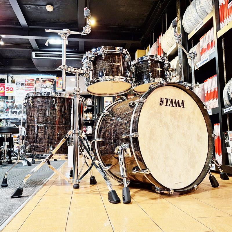 楽器種別：新品TAMA/新品 商品一覧＞＞ドラム【455，000円〜855，000円】 商品一覧＞＞ドラムセット/TAMA 商品一覧＞＞安心してお買い物頂けるよう、スネアもシンバルも丁寧梱包でお届けします！TAMA STAR Maple 4pc Set [22BD，10TT，12TT，16FT/Tom Cymbal Combination Stand2本サービス！]商品説明【TAMAのフラッグシップモデル、スターメイプルのドラムセットが入荷です！】〜STAR Maple Drum Kits〜STAR DrumはStarclassicで培ったシェルの鳴りを引き出すノウハウを、更に一歩推し進めた新たなフラッグシップモデルです。シェルには豊かな鳴りとファットなトーンが持ち味のブビンガシェルと、明るくオープンなサウンドのメイプルシェルをラインナップ。特徴あるシェル構成や新たなタムマウント方式Super Resonant Mounting Systemといったサウンドを向上させる革新的アイデアに加え、Quick-Lock Tom Bracketのようなセットアップの利便性を図る新しいアイデアも凝縮されています。熟練の日本人職人の技術と革新的なアイデアが融合した究極のドラムサウンド。それがこのSTAR Drumです。＜STAR Maple＞ドラムシェル・マテリアルの中でも、最もポピュラーで古くから使われてきた木材、メイプル。STARドラムではこれまでに無いシェル構成を採用することで、既存のメイプルシェルとは異なるサウンドを生み出しています。そのシェル構成とは、中央の1プライに通常より厚い2mmの材をコア・プライとして使用し、その内側と外側にそれぞれ2プライ1.5mm厚のメイプルで挟み込むというもの。このコア・プライとプライウッドの組み合わせにより強靭な強度を得たことで、一般的に厚くなりがちなソリッドプライ(単板)シェルのサウンドキャラクターを5mm厚という極薄シェルで実現しました。このユニークなシェル構成により、STARのメイプルシェルは通常のメイプルシェルが持つ明るくオープンなサウンドに加え、豊かなダイナミクスと芯の太いサウンドを獲得しました。-TAMAが想う最高のドラムその条件は・・・・シェルの鳴りを最大化しパワフルなストロークにも繊細なタッチにも素直に反応する 【高いシェルレスポンス】・ドラム同士の不要な共鳴・干渉を低減し、それぞれのドラムを気持ちよくならせる 【クリアな音の分離】・柔らかく食い込むような打感で、心地よい演奏感と手首への負担を軽減する 【心地よい演奏感】この3つを基に細部にまでこだわり開発が行われました。そのデビューから20年近くTAMAのフラッグシップを担ってきた「STAR Classic」シリーズを超える今のフラッグシップモデルの実現にあたり、長年のドラム製造で得たノウハウと徹底した音への追求を形にする為に、他社フラグシップモデルにて採用されているカスタム性をあえて持たせず、自信を持って推奨するスペックにてラインナップを形成しました。【メイプル(5mm5ply w/Sound Focus Ring)】等圧プライを採用するドラムが多く存在する中で、あえて中央を厚手の1plyを2mm、外内2plyを合計1.5mmと変則的な設定。厚みある芯板の単板とも言える音のレスポンスと合板シェルならではふくよかさを実現しております。またSound Focus Ring（レインフォースメント）も、同様なセンター2mmの5ply構成を採用しております。アウター1plyに「カーリー・メイプル（Curly Maple」を採用したフィニッシュは、美しく高級感溢れる仕上げとしております【ベアリングエッジ】ドラムの音の印象や鳴り方を司りドラムヘッドとドラムシェルの接地面となるエッジ部分は従来のシリーズよりも約1mm内側(外側から3.5mm地点/スタークラシックは2.5mm)に頂点を持ってくることで、丸みを帯びたハーフラウンドエッジとも言える形状のベアリングエッジを実現しました。ビンテージドラムなどに見られる形状で音をふくよかに丸くするとともにヘッドへの接地面積を増やし、よりヘッド振動をシェルへ伝える機構となっております。【新デザイン・ワンピースラグ】新しくデザインされたラグは、小ぶりなデザインを採用し、シェルとの接触面を可能な限りまで小さくした、ブリッジタイプです。小さめのラグにすることで、スネアドラム本体の重量を軽くするとともに、13、14ともに8テンション仕様にあえてこだわりました。パーツ点数を少なくすることで、シェル本来のもつポテンシャルをよりオープンに、かつレゾナンス豊かにします。【エアホール】STARシリーズのスネアドラムは、シェルの水平方向の中央部分に3つのエアーホールが取り付けられています。通常のエアーホールが1つのシェルと比較して、より明るく、ドライなサウンドを生み出します。また、金属パーツではなくメイプル製のエアキャップを使いシェル振動への影響を最小限に抑える工夫がされています。●Die-Cast Hoops w/mountフープはサウンドとチューニングの容易さを左右する重要なパーツです。STAR Drumsでは、高い剛性を持つ亜鉛ダイキャスト製フープを採用しており、ヘッドとフープの接触面を常に垂直に保ちシビアなチューニングにも敏感に対応します。基音のはっきりしたパワーのあるサウンドも大きな魅力です。加えて、タムタムにはシェルを3点で保持するSuper Resonant Mounting Systemを採用。シェルやフープへの負担を軽くし、タムタム自体を自然に鳴らすことを可能にします。更に、タムタムのレゾナンスを最大にするために、シェルとマウントが接する部分に全てラバーパーツを装着することで、ショットによってタムタムに加わった振動がスタンドへ逃げることを防ぎます。●Bass Drum Spursドラムペダルで打面をヒットした際に力の掛かるバスドラム・スパー(脚棒)には、ソフトでサイズの大きめのラバー・フィートを採用。これによりバスドラム・シェルが本来持つ自然なレゾナンスを生み出すとともに、ビーターの打面への快適なフィールを与えます。また、プレイ中のバスドラムの滑りを防ぐために用いられるスパイクにも、画期的なアイデアを取り入れています。通常、レッグの部分とスパイクは同軸構成になっていますが、STAR Drumsではこの2つを分離させた2ピース構造を採用。バスドラムをヒットした際の衝撃をスパイク自体に伝えにくくすることで、よりバスドラムのシェルを自然に『鳴らす』ことが出来ます。●Minimum Shell Contactドラムに付いている様々なパーツは、シェルのレゾナンスとサウンドに影響を与える要素となります。そこで STAR シリーズの開発にあたり、あらゆるパーツをシェルのレゾナンスを最大に生かすために慎重に設計。STAR ドラム専用に新しくデザインされた小ぶりで洗練されたデザインのラグは、シェルとの接触面を可能な限りまで小さくしたブリッジタイプ。バスドラム・フープに使われるクロー・フックも同様に、フープから フローティング した状態で保持する新構造。更に、シェルの空気穴にはメイプル材のエアホール・キャップを、マークは転写エンブレムをシェルの塗装に塗りこめる方式を採用するなど、振動するシェルへの負荷を最小限に抑えたレス・マウント設計です。●Die-Cast HoopsSTAR ドラムでは、高い剛性を持つ亜鉛ダイキャスト製フープを採用しており、ヘッドとフープの接触面を常に垂直に保ちシビアなチューニングにも敏感に対応します。基音のはっきりしたパワーのあるサウンドも大きな魅力です。＜構成＞22x16 Bass Drum [TMB2216S-CBP]10x7 Tom Tom [TMT1007S-CBP]12x8 Tom Tom [TMT1208S-CBP]16x16 Floor Tom [TMT1614S-CBP]HTC807W[Roadpro Tom/Cymbal Combination Stand]×2 (サービス品)＜スペック＞シェル：5mm，5ply Maple＋1outer ply Curly Maple w/5mm Sound Focus Ringsフィニッシュ：CBP(チャコール・ブラウン・パライソ)フープ：Bass Drum - Maple / Tom Tom & Floor Tom - Die-cast Hoopsタムマウント：Super Resonant Mounting Systemヘッド：Bass Drum Batter REMO Coated Powerstroke 3 /Front REMO Fiberskyn Powerstroke 3 Diplomat、TomTom&FloorTom Top REMO Coated Ambassador / Bottom Clear Ambassador※店頭展示、試打を解禁しておりますため、多少のキズやヘッドに打痕がある場合がございます。予めご了承くださいませ。イケベカテゴリ_ドラム_ドラムセット_TAMA_新品 SW_TAMA_新品 登録日:2026/02/28 ドラムセット ドラムキット タマ