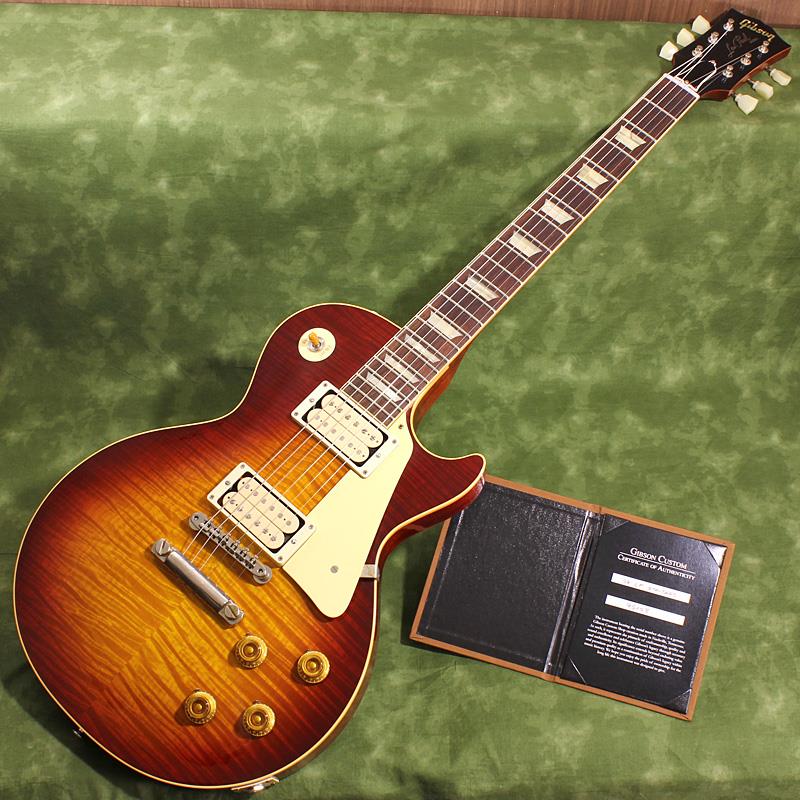 楽器種別：ユーズドGibson/Custom Shop 商品一覧＞＞Gibson/ユーズド 商品一覧＞＞エレキギター【555，000円〜1，040，000円】 商品一覧＞＞レスポールタイプ/Gibson 商品一覧＞＞当店のギターは、出荷前に専門スタッフが検品・調整しているので安心です！Gibson USED 中古 1959 Les Paul Standard Reissue R-Top Vintage Gloss Dark Cherry Burst SN. 9 5158商品説明ゴージャスな表情で魅せる「R-Top」を使用した1959 Les Paul Standard Reissueの2025年製中古品が入荷！当店での新品販売後に実用的なノイズレス加工が施された、プレイヤー向けのお買い得中古品です。お見逃しなく！標準的に1959 Les Paul Standardに使用されるフィギュアドメイプルよりもさらにハイグレードな「R-Top」材を贅沢にもハンドセレクトしオーダーしたスペシャルモデルが入荷しました。VOSよりも控えめで絶妙な使用感を演出した雰囲気の良いVintage Gloss仕上げとも相まって、ギラギラと立体的に揺れる悶絶美麗杢が貴方を甘美なバーストの世界へ誘います！エレキギター史に燦然と輝く1959 Les Paul Standard Model。数々のミュージシャンを虜にした圧倒的な存在感を放つサウンド、そして艶かしく弾き手を魅了する美しいボディラインは現代に於いても全てのロックギタリスト憧れのアイコンと言えるでしょう。1951年発売以来のゴールドトップ期を経て1958年にサンバーストフィニッシュを採用し、1960年までの僅かな期間にその姿で製作された「Les Paul Standard」。その中でも代表的年度として一際の人気を誇る「1959」モデルは常に羨望の眼差しを集める偉大な存在として君臨し続けております。そんな「1959」モデルを現在のGibson Custom Shopの技術の粋を結集し製作した一本です。究極のリイシューモデルとして2015年に登場したTrue Historicスペックを大部分で踏襲した2018年仕様をベースに、細部に亘りさらなる拘りを持って製作された2019年の60th Anniversaryモデルと同等スペックの最新入荷品です！60th Anniversaryモデルの発売時には、ギターのまさに「顔」とも呼ぶべきヘッドの「Les Paul MODEL」シルクスクリーンの色合いの見直しの他、Gibsonロゴデザインもよりオリジナルに近いデザインにリファイン。インレイは指板ポジションマークも含め、着色によるものではなく元々色合いの濃いセルロース素材を使用することで一層雰囲気を高めています。基本的なスペックは最新のHistoric Specを踏襲しつつも今回のCustombuckerはマニアックなバーストファンの方には堪らないDouble Classic Whiteのオープンカバーでの入荷です。さらに今回の選定材を使用したオーダーに合わせマグネットにアルニコ4を特別に採用し、通常のアルニコ3モデルよりもドライブ感を増したデザインとなっております。軽微なエイジングが施されたカバーも付属致しますので両側or片側をお好みで取り付けることも可能です。ボディバックのエンドピン付近に塗装欠けの他、微細な擦れ痕が数箇所見られますが全体的にはかなり綺麗で、フレットの減りもほぼ感じられず演奏面もバッチリの中古品です。前オーナー様所有時に弊社リペア工房WSRにてノイズレス加工としてバックキャビティとPUキャビティに導電塗料の塗布とアース処理が施されています。Factory BurstやWashed Cherry等のレギュラーなチェリーサンバースト系よりもダークに沈んだ深い色合いが堪らなくグラマラスな1本です！ぜひお早めにご検討下さい！Serial No. 9 5158Weight≒3.90kg専用ブラウンケース、カスタムショップ認定証、PUカバー 等 付属商品詳細Body: Hand Selected 2-Piece Figured Maple Top (R-Top) & 1-Piece Lightweight MahoganyNeck: Solid Mahogany with Long Neck Tenon / 50s Rounded Medium C ShapeFingerboard: Indian RosewoodFrets: Historic Medium-Jumbo 22FretsPickups: Custombucker Alnico 4 (Unpotted)Controls: 2 volume 、2 tone 、3-way switchBridge / Tailpiece: ABR-1 non wire / Lightweight Tailpiece w/Long StudTuners: Kluson Single Line， Single RingHardware color: Nickelイケベカテゴリ_エレキギター_レスポールタイプ_Gibson_Custom Shop_ユーズド SW_Gibson_ユーズド JAN:2500010896993 登録日:2026/06/25 エレキギター ギブソン カスタムショップ