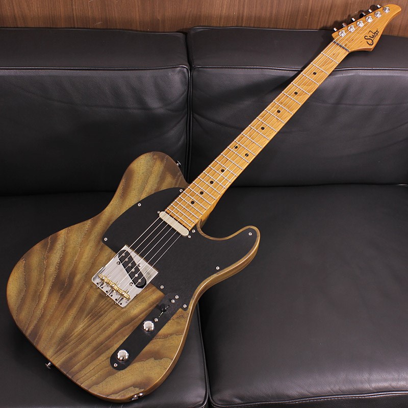 楽器種別：新品エレキギター/Suhr Guitars 商品一覧＞＞エレキギター/Suhr Guitars/SIGNATURE SERIES 商品一覧＞＞エレキギター【495，000円〜925，000円】 商品一覧＞＞当店のギターは、出荷前に専門スタッフが検品・調整しているので安心です！Suhr Guitars Signature Series Andy Wood Signature Modern T Classic Style Whiskey Barrel SN. 71567商品説明Suhrファンの方にはお馴染みの技巧派ギタリストAndy Woodがスペシャルと語るシグネチャーギターが入荷致しました。ボディにフィットするコンター加工が施されたTLスタイルのアッシュボディ、クリスタルトーンを構築するRoasted Mapleネック、技巧派の心をくすぐる24フレット仕様、フィンガリングし易いネックジョイント部のカッタウェイ加工、シグネチャーモデルのWoodshedピックアップ、ハムノイズキャンセルシステムSSCIIの搭載等、一見するとクラシカルなシルエットですが極上のサウンド＆プレイアビリティーを兼ね備えている、シグネイチャーモデルならではのアーティストスペックが味わえる逸品です。まず目を惹くのは美しい木目が浮かび上がったウイスキーバレルカラーのアッシュボディ。一般的にはあまり見かけない仕上げですが、なんとアッシュボディをバーナーで燃やすというBurned加工が成された後、サテン(艶なし)のブラウンカラーを吹き仕上げるTorched Stain Finishが施されております。アッシュ材特有の大きい導管が織りなす木目と相まって、木の温かみを感じる心地よい手触りもあるユニークな仕上がりとなっております。更にルックスの肝となるピックガードとコントロールパネルがアルミニウム/ブラックアノダイズドで製作されており、フィニッシュとの組み合わせで精悍さを演出しております。ブリッジはSuhrのTスタイル定番のWilkinson製を使用しております。独自の3ウェイサドルのダイレクトさとイントネーション（ピッチ）の良さが両立し、プレートの両脇をカットしている事での演奏性の良さもございます。一般的なTLプレートでは難しいですが、ブリッジミュートもストレス無く出来るのは嬉しいですね。ネック材にセレクトされたRoasted Mapleは、メイプルネックのサウンドの質感に抜群のスタビリティーを持たせる事で心地よいサスティーンとバイブレーションをもたらし、Roasted Mapleならではの澄み切った透明感有るサウンドをご堪能いただけます。ネックシェイプはModernでは定評のあるシェイプ、Modern Elliptical .780-.830を採用。グリップ感もよく正に自然にフレージングが湧き出てくるネックシェイプです。フレットにはJumbo Steinless Steelをセレクトし、絶妙のレスポンスとクリアーなタッチを堪能出来ます。また、指板ラジアスは16Rのスーパーフラットな仕様です。この全面16RはAndyからの希望で製作されたとのことで、シグネチャーモデルならではのユニークさ、抜群のプレイフィーリングが楽しめます。マウントされるPUはWoodshed。Classic Tのローワウンドタイプとなりますので、演奏時のタッチ感による抑揚が付け易い本格仕様です。もちろん、ハムキャンセルシステムSSCII(Silent Single-Coil)を搭載しており、環境ごとに異なるノイズにも順応に対応可能で、ハイゲインなセットアップでも個体のトーンを失わなずにローノイズでアウトプットしてくれます。世界が注目するハイレベル技巧派ギタリスト、Andy Woodの要望を随所に組み込んだ至高のシグネチャーモデル。ヘッドバックに刻まれたサインは彼がこのギターの実力を認めた証です！Serial No. 71567Weight≒3.12kg＊正規輸入品＊専用ハードケース、スペックシート、レンチ類、フレットガード　付属商品詳細【SPECS】Body Wood: Swamp Ash，2-PieceBody Color: Whiskey BarrelFinish: Torched Stain FinishBridge: Wilkinson 3 SaddleNeck&Finger Board Wood: Roasted MapleRadius: 16inchNeck Shape: Modern Elliptical .780-.830Frets: 24 Frets，Jumbo SSTuning Gears: Suhr LockingElectronics: Volume，Tone，3-WayNeck P.U: Woodshed NeckBridge P.U: Woodshed BridgeCase: Hardshell Case，Blackイケベカテゴリ_ギター_エレキギター_Suhr Guitars_SIGNATURE SERIES_新品 JAN:4571220082078 登録日:2023/12/30 エレキギター サー Shur