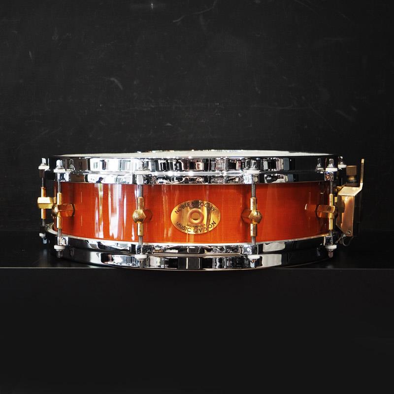 楽器種別：ユーズドNOBLE&COOLEY/ユーズド 商品一覧＞＞ドラム【80，000円〜160，000円】 商品一覧＞＞スネアドラム/NOBLE&COOLEY 商品一覧＞＞安心してお買い物頂けるよう、スネアもシンバルも丁寧梱包でお届けします！NOBLE&COOLEY USED 中古 Solid Shell Classic Series Maple 14×3.875 Snare Drum商品説明【老舗のハンドメイドドラムメーカー、「Noble & Cooley」のソリッドメイプルスネア中古品が入荷！】＜Noble & Cooley / Made in USA＞マサチューセッツ州グランビルの工場にて製造を行っているノーブル・アンド・クーリィ社は、150年以上の歴史を誇る老舗のハンドメイド・メーカーです。ニューイングランド地方の最高品質の木材を使用する等、マテリアルの質や美しいパーツデザインにこだわり、長年に渡り唯一無二のサウンドクオリティを提供しています。＜SS Classic Solid Series Maple＞単板メイプルに同じく単板メイプルのレインフォースメントを装着したNoble & Cooleyの代表的なモデルの一つです。しなやかなで繊細なタッチが持ち味で、アンサンブルや楽曲に溶け込みつつ、細かなスティックワークに対してセンシティヴな反応を発揮します。こちらはNoble & Cooleyの極めて正確な加工精度によって、3.875インチという独特な深さで製造されたモデルです。浅胴でありながらも単板特有の暖かみのある鳴りが豊かに得られ、ハイレスポンスと軽快かつ芯のあるスティックサウンドを発揮します。-The Industry Legend-ノーブル＆クーリー初のプログレード・ドラム製品であるSSクラシックは、エレガンスとレゾナンスの完璧なコンビネーションを誇り、世界中のアーティストに愛用されています。このスネアドラムは現代における最初のスチームベント・ソリッド・シェル・ドラムで、1980年代初頭に登場して以来、数え切れないほどのレコーディングで使用され、世界最高のドラムを製造するトップメーカーとしての名声を確固たるものにしました。そして今日でもプロ・プレイヤーに選ばれ続けています。-SOLID SHELL-ソリッド・ロックメイプル（またはその他の国産広葉樹）は、木目の一貫性を保つためにハンド・ピッキングされ、歴史あるスチーム・ベンディング工程を経ています。単板のシェルは、一般的に使用される複数枚板のシェルよりも自由に振動し、SSクラシックに暖かさと繊細なタッチを与えています。-BEARING EDGE-ベアリング・エッジは、シェルとドラムヘッドの接触点です。このベアリング・エッジの加工精度がドラムの音色とチューナビリティを決定します。ノーブル＆クーリーのエッジは、最大限の響きとプロジェクションを生み出すために旋盤加工されています。1万分の1インチ単位で正確に加工されたベアリング・エッジは手作業でカットされ、機械工グレードの花崗岩の平面で2度チェックされます。この正確な加工精度により一貫したピッチやチューニングレンジが保証されます。-NODAL POINT LUG MOUNTING-ノードル・ポイント・テクノロジーは、ノーブル＆クーリー独自の特許です。シェル振動の自然な波長の節点にラグポストを配置することで、本来の音色を生み出す振動がラグの質量の影響を受けないようにしています。シェルそのものがドラムの究極の音色に加わるのです。＜スペック＞口径×深さ : 14インチ × 3.875インチシェル : 6.3mm ソリッドメイプル ＋ ソリッドメイプルレインフォースメントフィニッシュ : Gloss Lacquerフープ / ダイキャストフープ10テンションラグ : オリジナルブラスチューブラグストレイナー : オリジナルブラススローオフ※中古品のため細かなキズや汚れなどがございます。予めご了承くださいませ。※チューニングボルトのナイロンワッシャーが経年劣化により割れやすくなっております。イケベカテゴリ_ドラム_スネアドラム_NOBLE&COOLEY_ユーズド SW_NOBLE&COOLEY_ユーズド JAN:2500190058686 登録日:2026/05/18 スネア スネアドラム