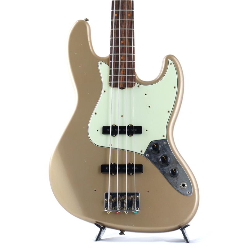 楽器種別：新品Fender Custom Shop/Custom Built Jazz Bass 商品一覧＞＞Fender Custom Shop/新品 商品一覧＞＞ベース【550，000円〜1，025，000円】 商品一覧＞＞エレキベース/JBタイプ/Fender Custom Shop 商品一覧＞＞当店のベースは、出荷前に専門スタッフが検品・調整しているので安心です！Fender Custom Shop Limited Edition 1964 Jazz Bass Journeyman Relic (Aged Shoreline Gold)商品説明【Fender ロゴ入りキャンピングチェアプレゼント】Fender Custom Shopのベース本体をご購入でロゴ入りオリジナルキャンピングチェア(非売品)をプレゼント！小型かつ軽量で、折り畳みも可能なため持ち運びや収納にも便利なアウトドアチェア！通常は購入のできないレアアイテムを手に入れるチャンスをお見逃しなく！対象商品：新品のFender Custom Shopベース本体ご購入でプレゼント※数量限定プレゼント品のため、無くなり次第終了となりますので予めご了承ください。※アウトレット品、セール品、リユース品/中古品、受注生産品など、一部商品は対象外の場合も御座います。ーーーーーーーーーーーーーーーーーーーーーーーーーーーーーーーーーーーーーーーーーーーーーーーーーーーーーーーーーーーーーーーーーーーーーーーーーーーーーーーーーーーーーーーーーーーーーー「エイジド・ショアライン・ゴールド」をレリックフィニッシュした王道64ジャズベース全世界のフェンダーカスタムショップ認定ディーラーを対象に不定期に開催されるトレードショウのために特別に製作されたカタログ未掲載のモデルから、特に人気の高いギターやベースを厳選した「Limited Edition」。この限定モデルは、カスタムショップのエキスパートたちによって手がけられ、独自の特徴とクオリティを備えています。厳選された2ピースのアルダー材ボディ、ネックは厳選されたメイプル材、指板には比較的濃い色合いのローズウッドをラウンド貼り、程よい厚みが確保された印象のU Shapeネックグリップによって、しっかりとした身が詰まった硬質な質感と弾力あるトーンが感じられ、ピッキングした際の力強さと響きが良く伝わり、楽器の鳴りを存分に体感できる仕上がりとなっております。その芯のあるトーンはアンサンブルでボトムを支えつつその存在感を大いに発揮してくれる事でしょう。そして何より個性を感じさせるのはそのルックス。絶妙な色焼け/色抜けを再現したかのような華やかさと渋味を持ち合わせた「エイジド・ショアライン・ゴールド」を採用し、ジャーニーマン・レリック加工にてフィニッシュ。パーツのくすみや塗装の質感など、適度な使用感とエイジングを演出し、その塗装の薄さからN.O.S.仕上げのモデルよりも適度に鳴ってくれ、まるで長い年月をかけてエイジングされた楽器かのような印象をうけます。ジャズベースらしいすっきりとしたサウンドと合わさることで、角が立ち過ぎずまろやかなサウンドを実現しています。フェンダーの代表的なフィニッシュ、クローゼットクラシックとレリックの中間位置にあるコチラのジャーニーマンレリックは、適度に弾き込んだかのようか質感と手や体に馴染むバランスが素晴らしく、過度なレリック加工も無い分シンプルにまとまっており、ライブ派プレイヤーの為のフィニッシュと言えるでしょう。フェンダーの王道にして上位クラスのサウンドに、アクセントの効いた個性的なルックスを織り込んだありそうで無い一本です。商品詳細Body : Alder 2Pc.Neck : Maple (Quartersawn)Neck Shape : 60 J-Bass UFinger Board : RosewoodFinger Board Radius : 7.25Number of Frets : 20Scale : 34inchNut : BoneElectronics : Hand Wired Vint J-BassControls : 2Volume， ToneFinish : Lacquer/Journeyman RelicWeight ≒ 4.40kg (両フェンス装着時)ハードケース付属イケベカテゴリ_ベース_エレキベース_JBタイプ_Fender Custom Shop_Custom Built Jazz Bass_新品 SW_Fender Custom Shop_新品 JAN:0717669563059 登録日:2026/07/24 エレキベース フェンダー ふぇんだー フェンダーカスタムショップ フェンダーCS ジャズべ ジャズベース