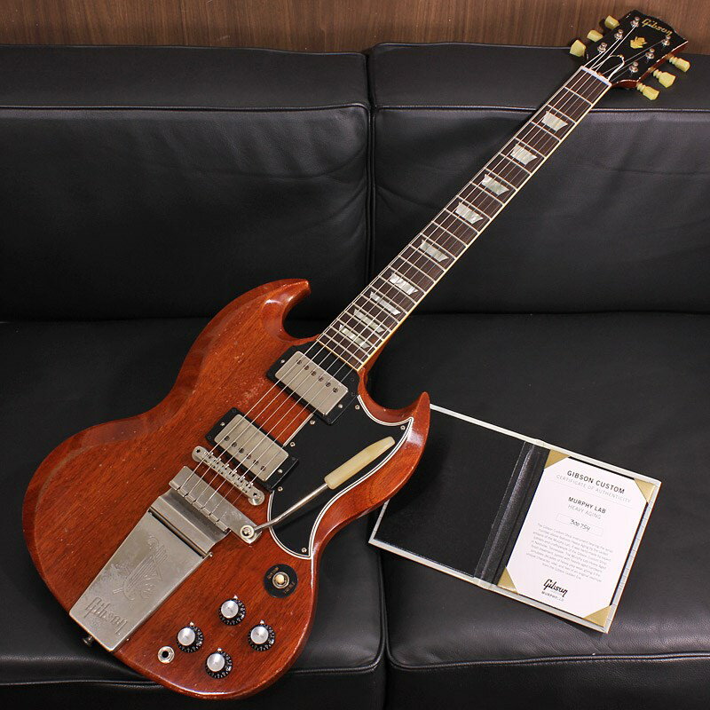 楽器種別：新品Gibson/Custom Shop 商品一覧＞＞Gibson/新品 商品一覧＞＞エレキギター【555，000円〜1，045，000円】 商品一覧＞＞SGタイプ/Gibson 商品一覧＞＞当店のギターは、出荷前に専門スタッフが検品・調整しているので安心です！Gibson Murphy Lab 1964 SG Standard Reissue with Maestro Vibrola Heavy Aged Faded Cherry SN. 300754商品説明〜 Murphy Lab 〜カスタムショップ内に誕生したMurphy Lab（マーフィー・ラボ）は、ナッシュヴィルのギブソン・カスタムショップ内に新設されたラボで、科学的検証に基づく最新の技術を駆使して、ギターのエイジング（ヴィンテージ・ギターの経時変化した外観と弾き心地を再現する処理）を専門に行います。ギブソン・カスタムショップの立ち上げ時のメンバーであり、ヒストリック・コレクション開発のプロジェクト・リーダーとして尽力したトム・マーフィーは、その後新品のギターにヴィンテージのルックスとフィーリングをもたらすエイジングというテクニックで活躍してきました。トムのヴィンテージ・ギターへの情熱と深い知識に裏打ちされた技術によって、ギブソン・ギターの自然なラッカーのクラック、演奏による摩耗を見事に再現しています。トム・マーフィーとギブソンは、経時変化によりウェザーチェックと呼ばれるクラックを生じさせる、1950年代、1960年代のニトロセルロースラッカーを科学的に解析し、その変化のプロセスをひも解き、あらゆるモデルのプロトタイプによるテストを重ねて、ヴィンテージ同様のナチュラル・ウェザーチェックを再現するラッカー・プロセスを開発しました。マーフィー・ラボは、トム・マーフィーがギブソン・カスタムショップのチームを率いて、プロトタイプをもとに、あらゆるボディシェイプ、フィニッシュ、エイジング・レベルの検証を始めたことから、その構想が生まれました。その結果、これまでにないリアリティとこだわりを追求したエイジングを行うために、ギブソン・カスタムショップ内に設立されました。トム・マーフィーの存在と、その芸術的な作品の数々は、ギブソンの歴史の中で重要な役割を果たし、今もそしてこれからもマーフィー・ラボとして永遠に引き継がれていきます。本機は4段階で設けられた中で3段階目のエイジングレベルとなる「Heavy Aged」が施された1964 SG Standard Reissue with Maestro Vivrolaです。1961年に販売が開始されたSGモデルは、当初デザインチェンジされたLes Paulモデルとして誕生しました。その後、Gibson社とLes Paul氏の契約が終了となった後、正式に「SG」がモデル名として採用されることになります。薄型のソリッドマホガニーボディには流麗なコンツァーが設けられ、取り回しの良さとオリジナリティ溢れるルックスを持ち合わせております。特徴的な深いダブルカッタウェイはシングルカッタウェイ構造のLes Paulモデルとは一線を画すハイポジションへの抜群の演奏性がもたらされており、22フレットをフルに活用したいギタリストの要求にも応えた設計となっております。Heavy Agedはツアーやギグによるハードなプレイにより、ネックやボディのフィニッシュが剥がれた状態やベルトのバックル傷を再現。ハードウェアにもMurphy LabによるHeavy Aged仕上げが採用されており熟練したMurphy Labの職人たちの妙技/エイジングが堪能できるモデルです。指板エッジにはロールド加工が施され、優れたグリップ感がプレイヤーの皆様にはさらに嬉しい仕上げとなっております。基本的なスペックは最新のHistoric Specを採用。ポッティング無しのCustombuckerを2基搭載し、コンデンサーはブラックビューティが装着されております。ヴァイブローラートレモロブリッジが生む独特なルーズさを持ったテンション感が生み出すクランキーで味のあるトーンがお楽しみいただけます。原点に回帰することでさらなる進化を続けるGibson Custom Shopの最新型の入荷です。Custom Shop製ならではの素晴らしいトーン、Murphy Labが生み出す迫力満点のエイジングをぜひご堪能下さい！Serial No. 300754Weight≒3.28kg商品詳細Body Wood : 1-Piece Solid Lightweight MahoganyNeck : 1-Piece Mahogany with Long Neck Tenon / Medium C-ShapeFingerboard : Indian RosewoodFrets : Authentic Medium-Jumbo / 22FretsPickups: Custombucker Alnico 3 (Unpotted)Controls : 2 volume 、2 tone 、3-way switchBridge / Tailpiece : ABR-1 non wire/ Maestro VibrolaTuners : Kluson Single Line， Double RingHard ware color : Nickel， Murphy Lab Heavy Aged専用ハードケース、Murphy Lab認定証 等付属イケベカテゴリ_エレキギター_SGタイプ_Gibson_Custom Shop_新品 SW_Gibson_新品 JAN:4580568421395 登録日:2023/03/23 エレキギター ギブソン カスタムショップ